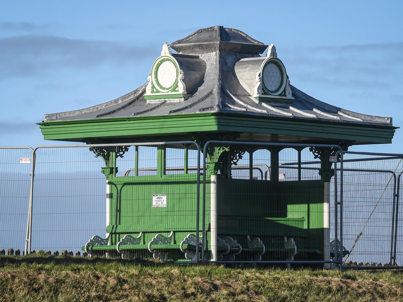 Queen's Promenade Shelter, probably l905. Cast iron with wooden side screens and partition, lead-covered roof.