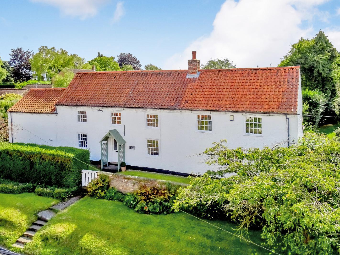 A charming Grade II listed detached period residence together with a double garage, private enclosed garden and occupying a prominent position in the centre of this sought after North Yorkshire village.