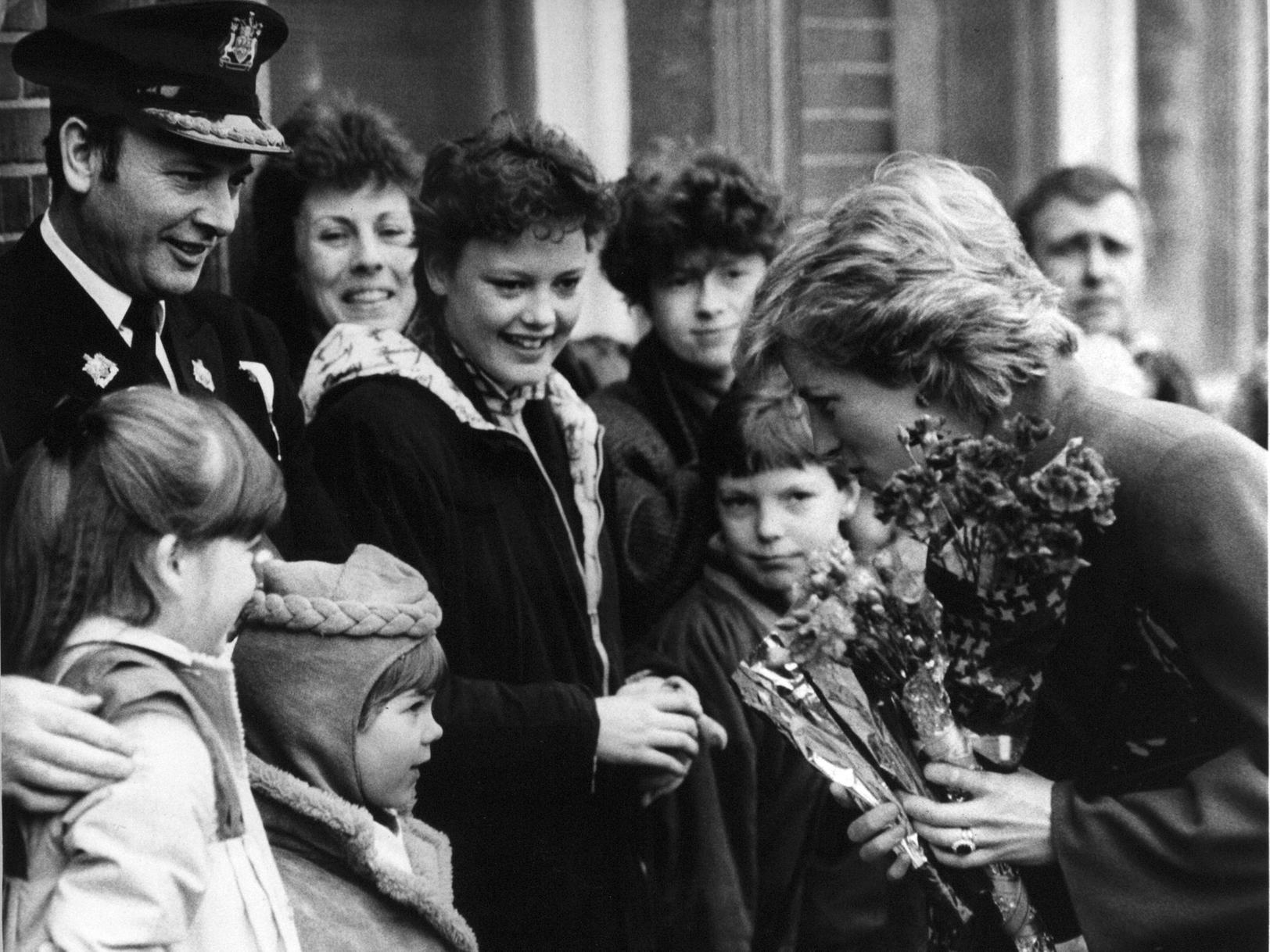 Princess Diana receives flowers from the crowd outside Centenary House during a visit to the city.