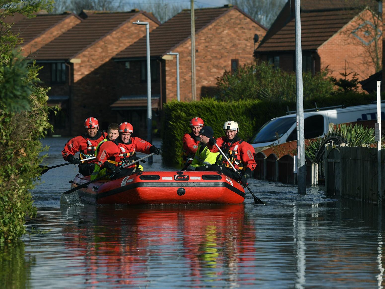 Firefighters make their way down George Street after flooding in Snaith, near Goole.