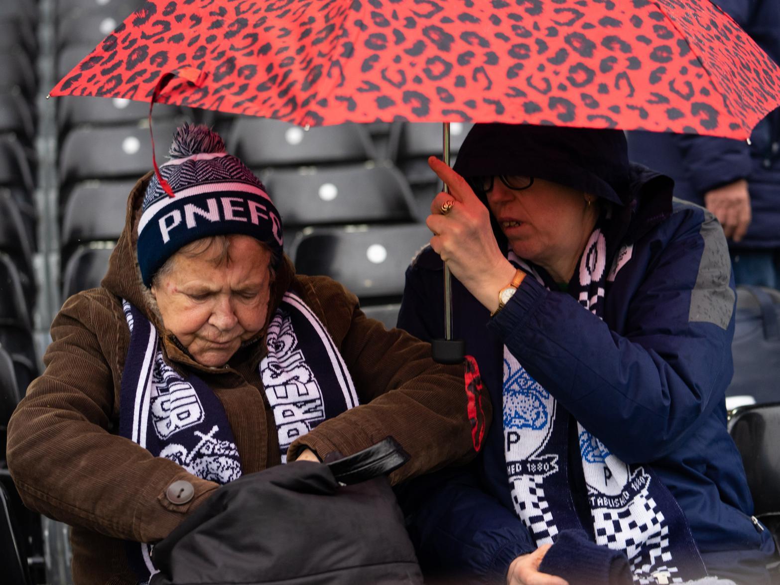 Two PNE supporters came prepared for the rain at Craven Cottage with the lower part of the travelling fans open to the rain.