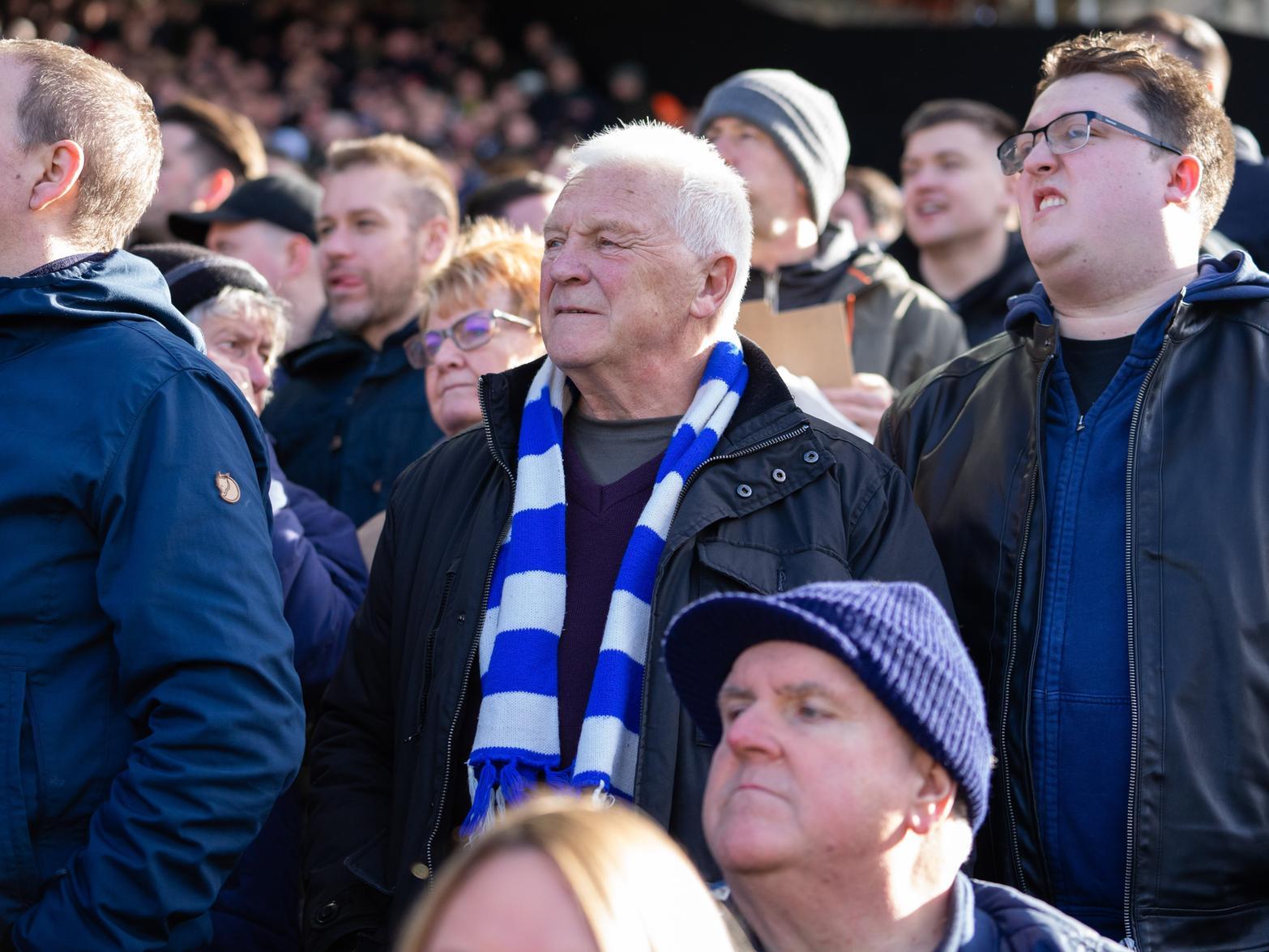 A traditional blue and white scarf is the choice for one fan in a packed away end.