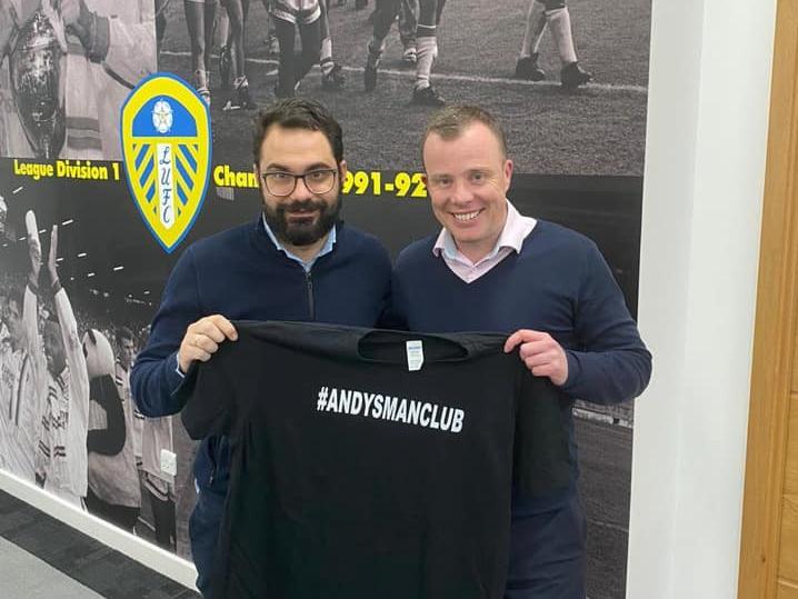 Leeds United's Victor Orta and Angus Kinnear holding an Andy's Man Club t-shirt.