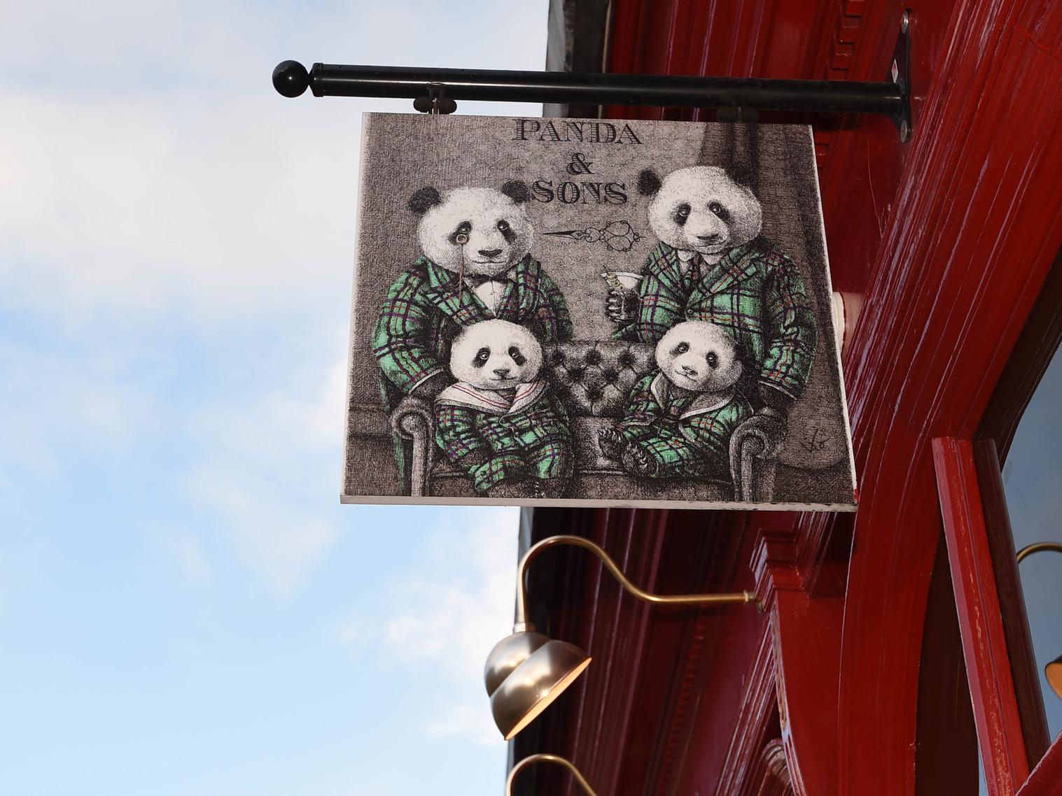 A quirky sign outside the bar shows a group of pandas dressed up in suits.