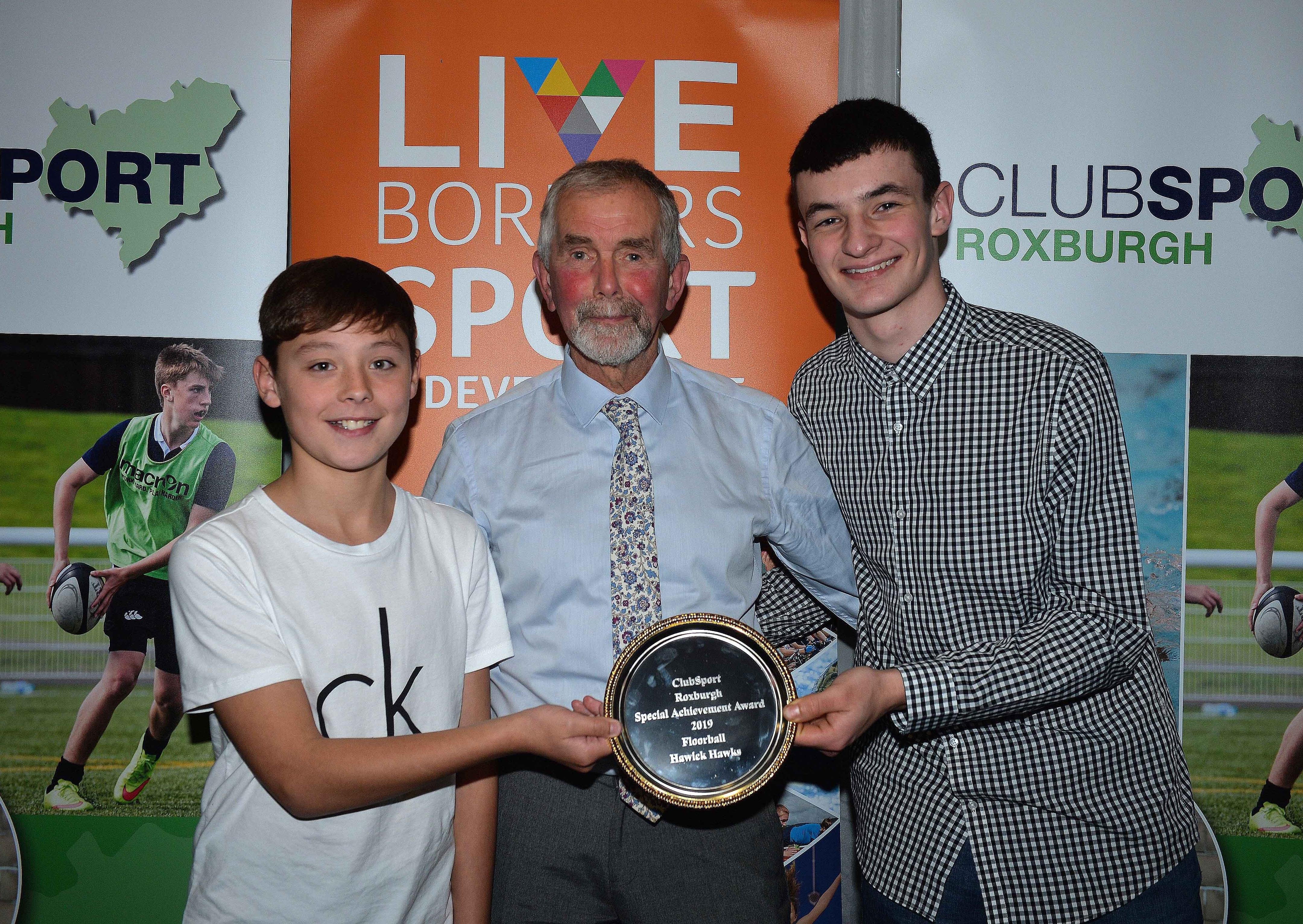 Trrevor Bryant, centre, handed over a Special Achievement Award to floorball players from the Hawick Hawks.