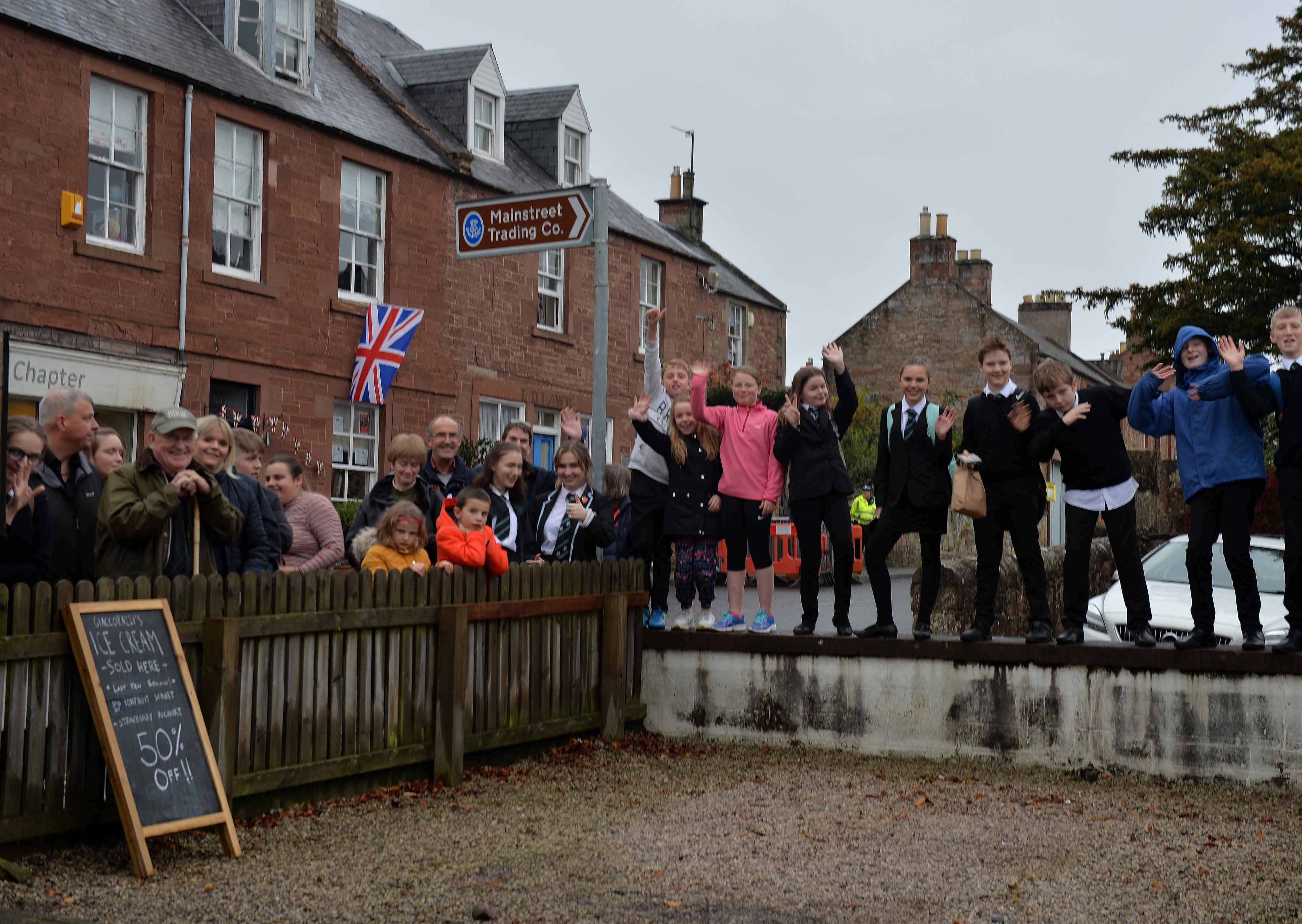 Youngsters and villagers wave farewell to the Duke.
