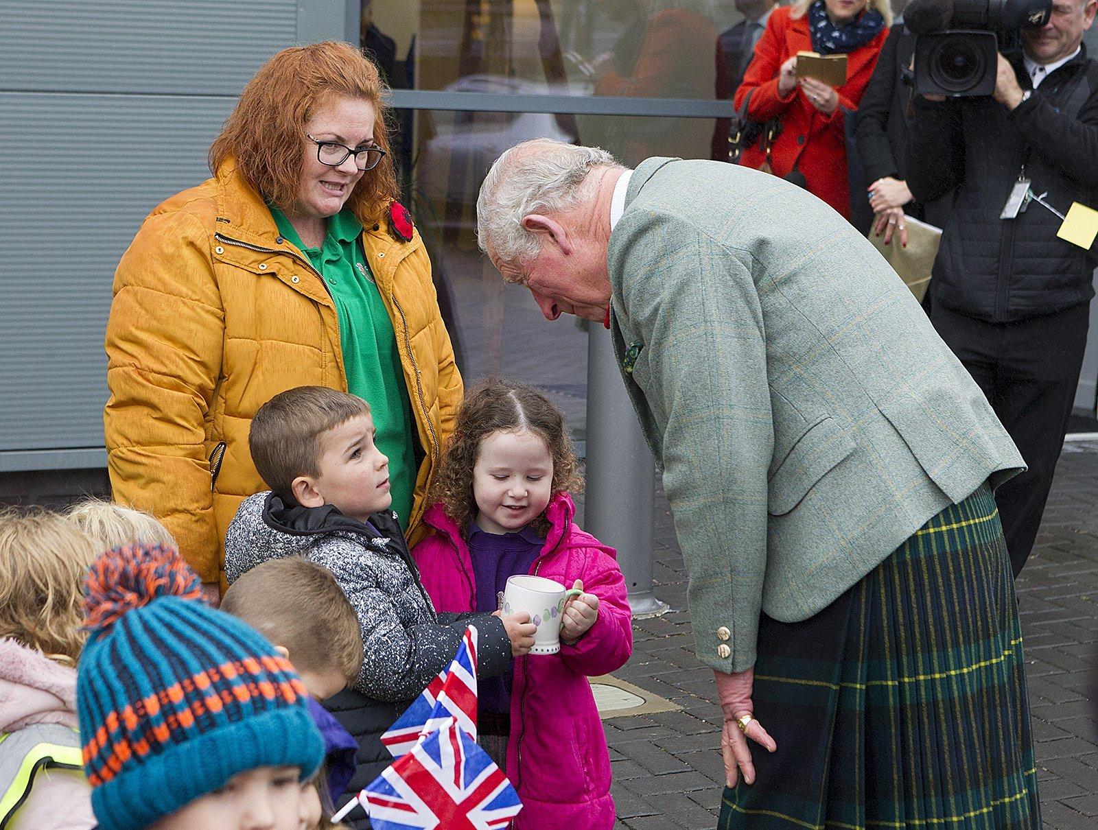 Wendy Scott and wiggly worms nursery pupils, Lockie Watson and Erin Hush present a mug to Prince Charles