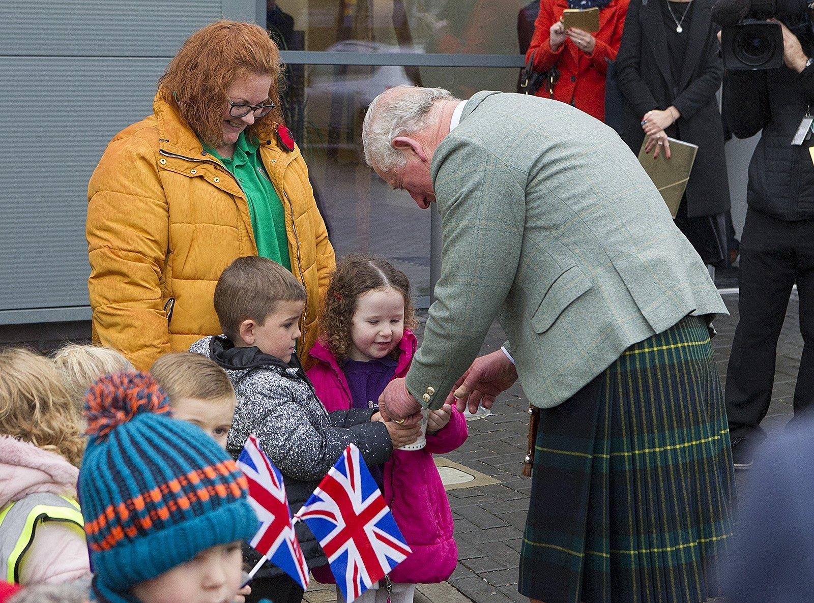 Wendy Scott and wiggly worms nursery pupils, Lockie Watson and Erin Hush present a mug to Prince Charles.