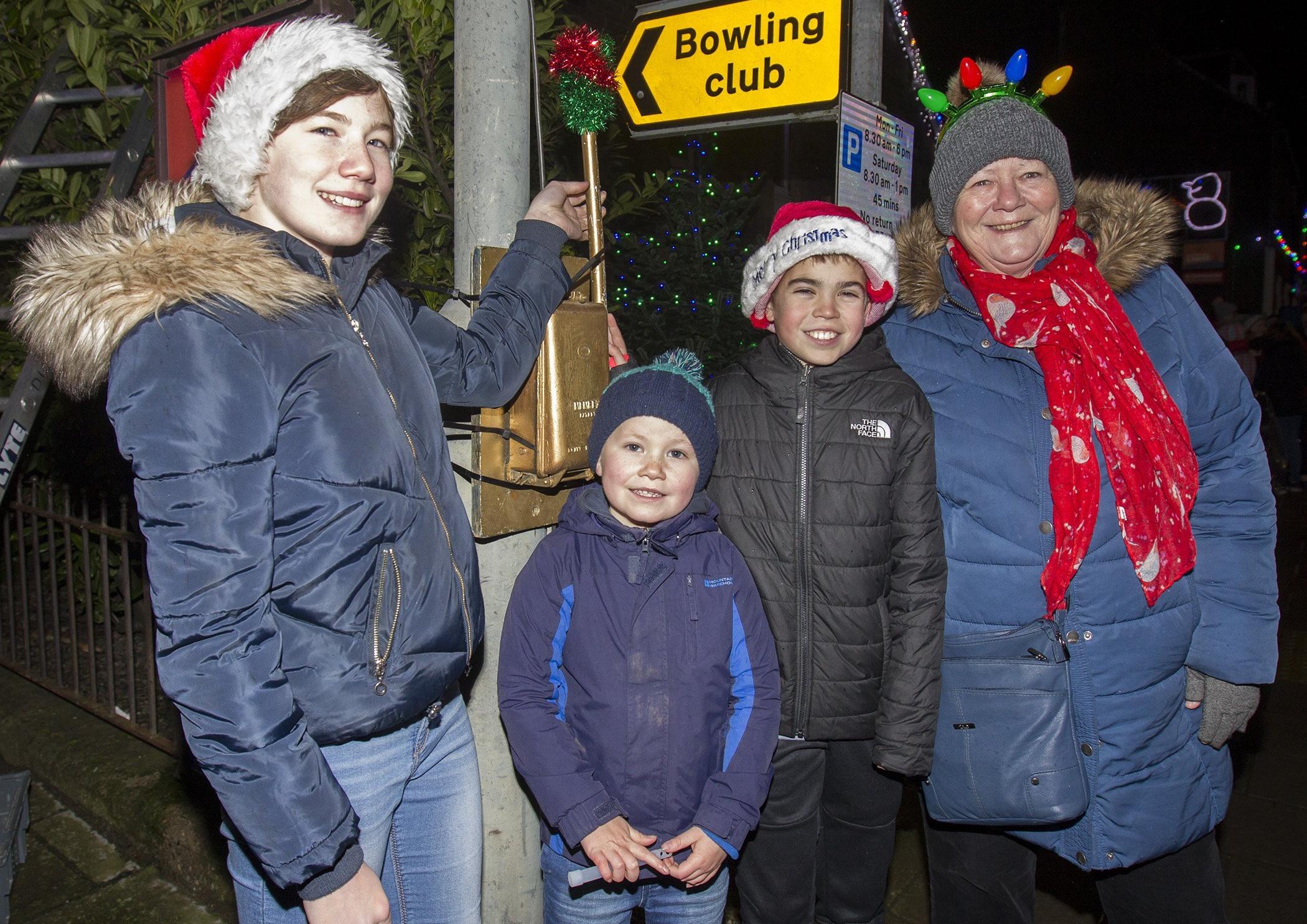 Dux Girl Grace Turnbull about to switch on the lights at Innerleithen with Struan, Aaron and event organiser Jean Wilson.