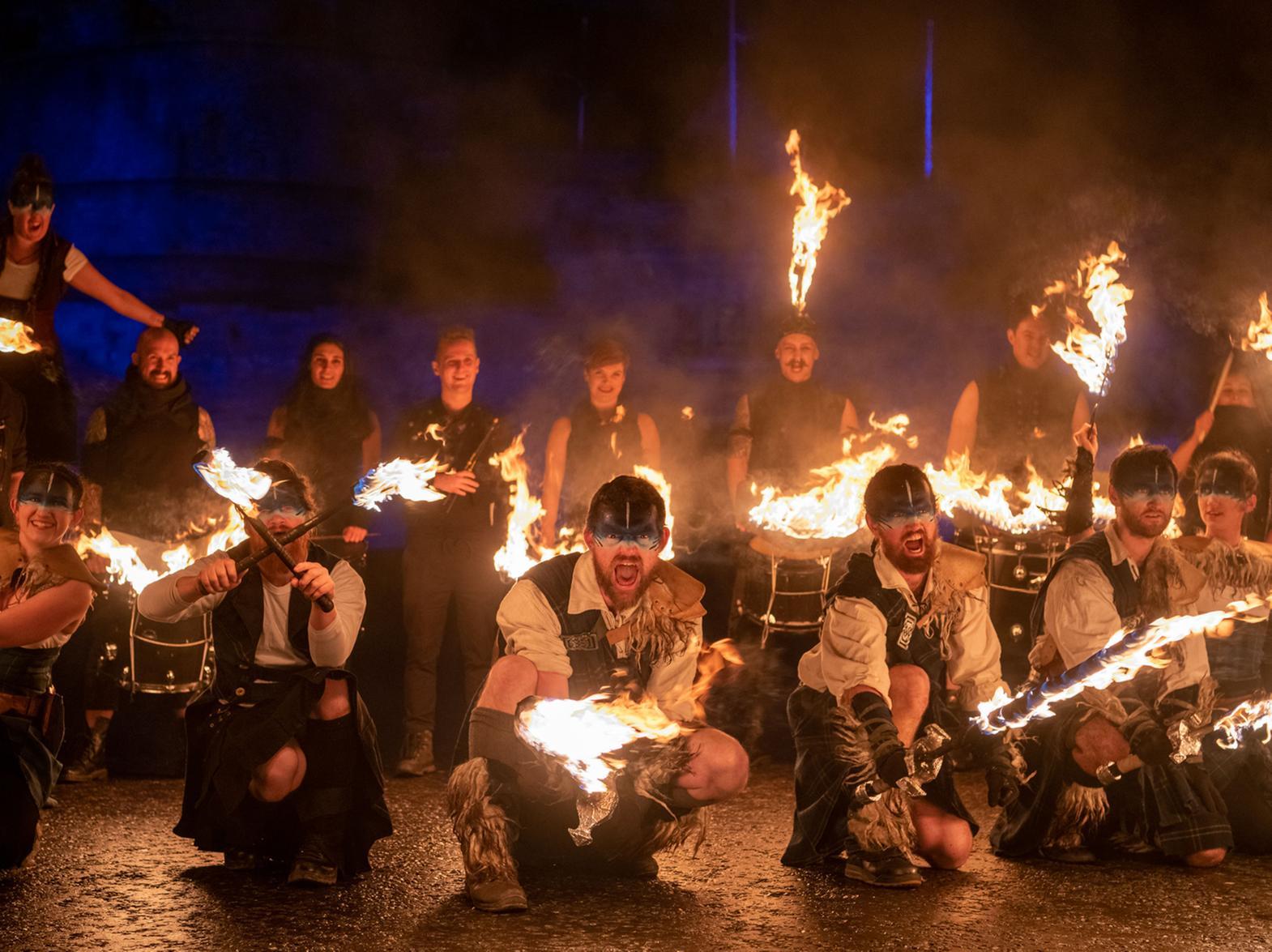 Fire-throwing artists and drummers led the 'river of light' to Holyrood Park, where event organisers say about 40,000 people gathered to create a symbol of friendship against the backdrop of the city.