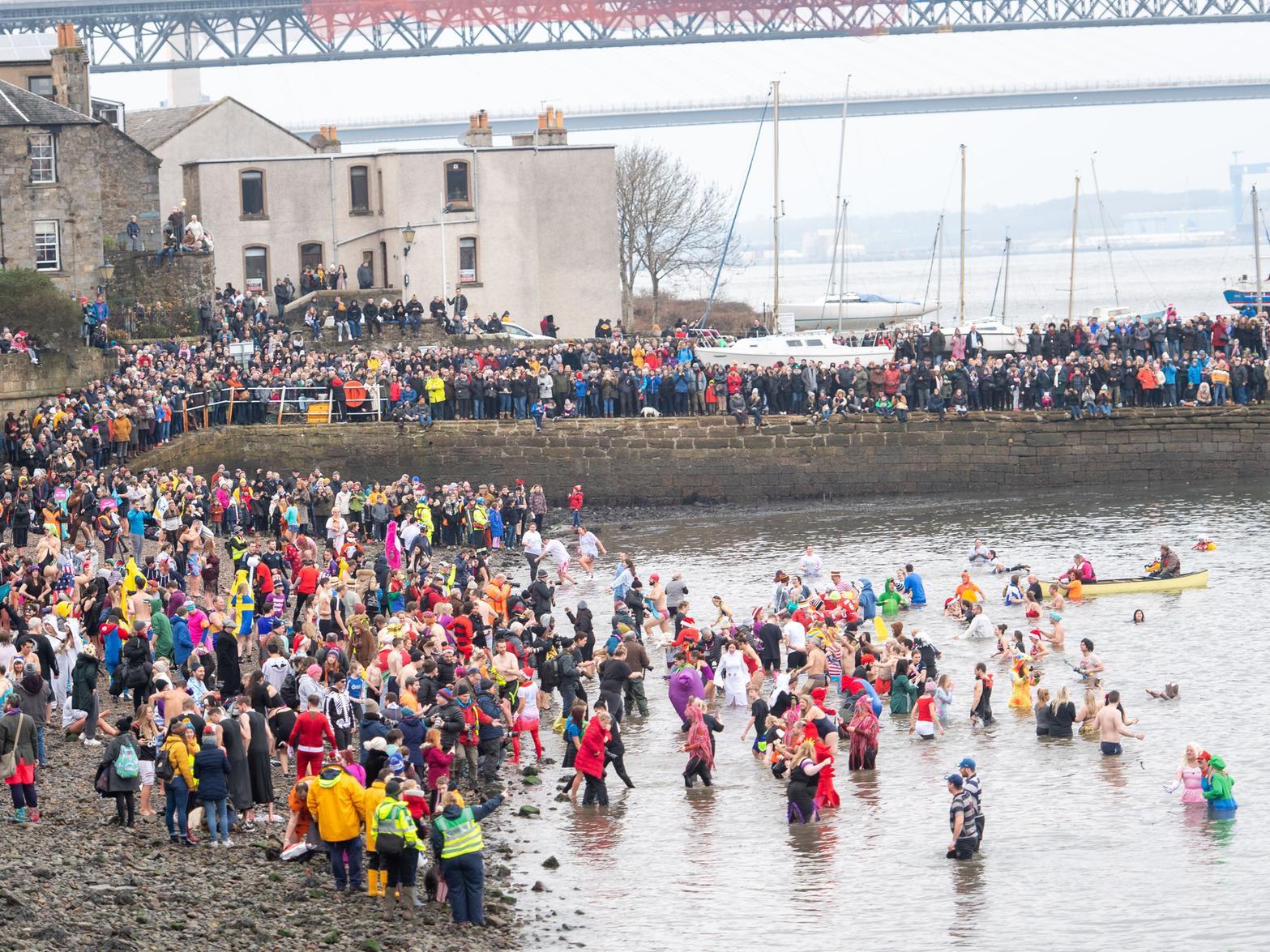 The New Year's Day tradition at South Queensferry, which dates back to 1987, saw all participants parading through its historic streets before entering the water.