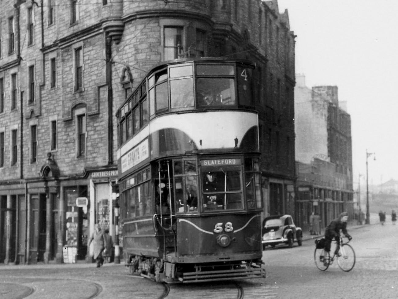 Turning into Slateford Road at Ardmillan Terrace, Tram 58 trundles by a typical Edinburgh street scene of the Fifties, complete with cyclist keeping well clear of the tram lines.