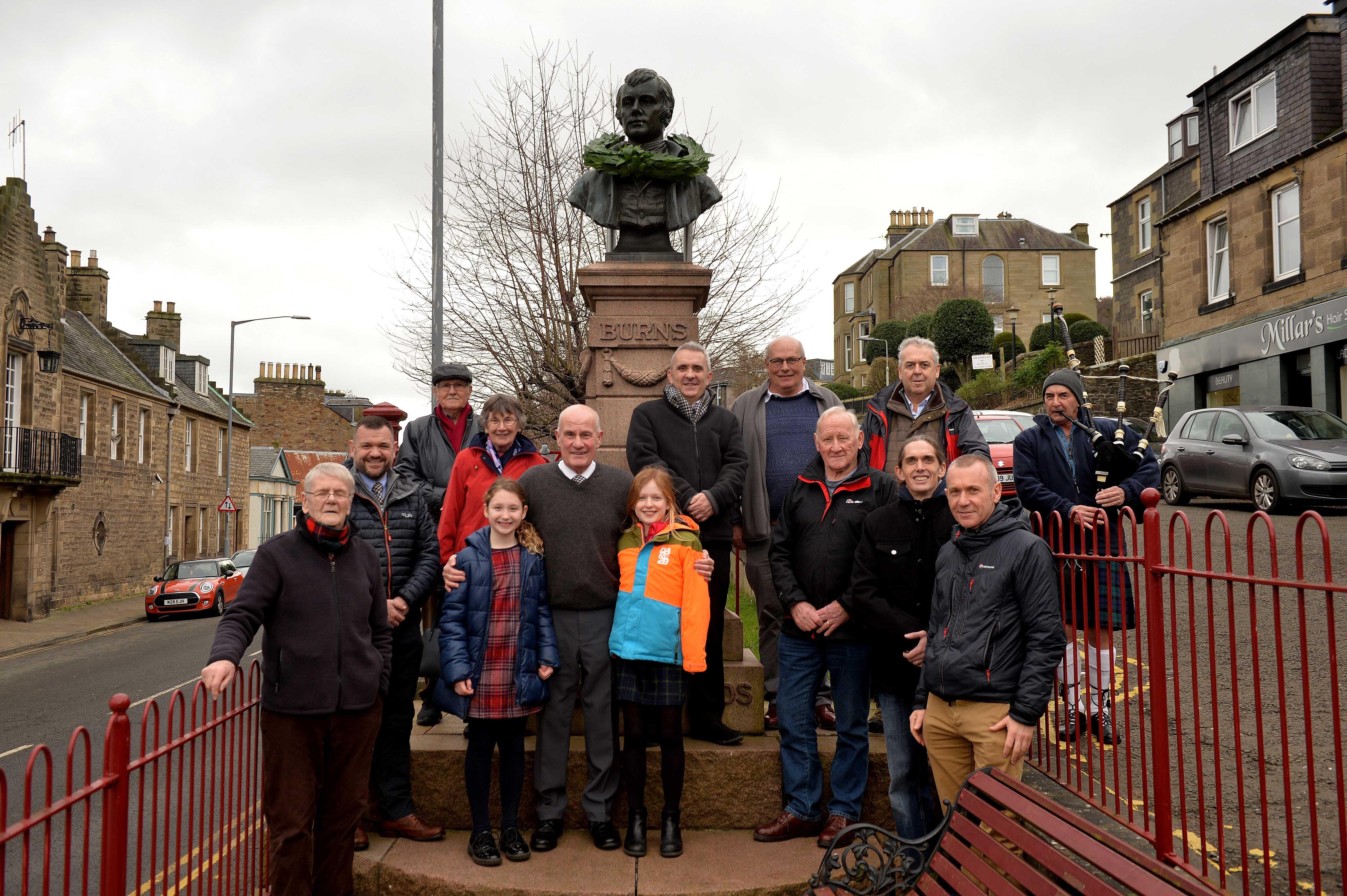 Members of the club at the Burns bust, located outside the town's library.