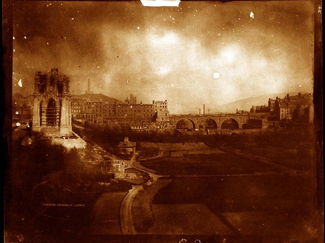 In this view from circa 1844, a half-finished Scott Monument rises from East Princes Street Gardens. The original North Bridge can be seen in the distance.