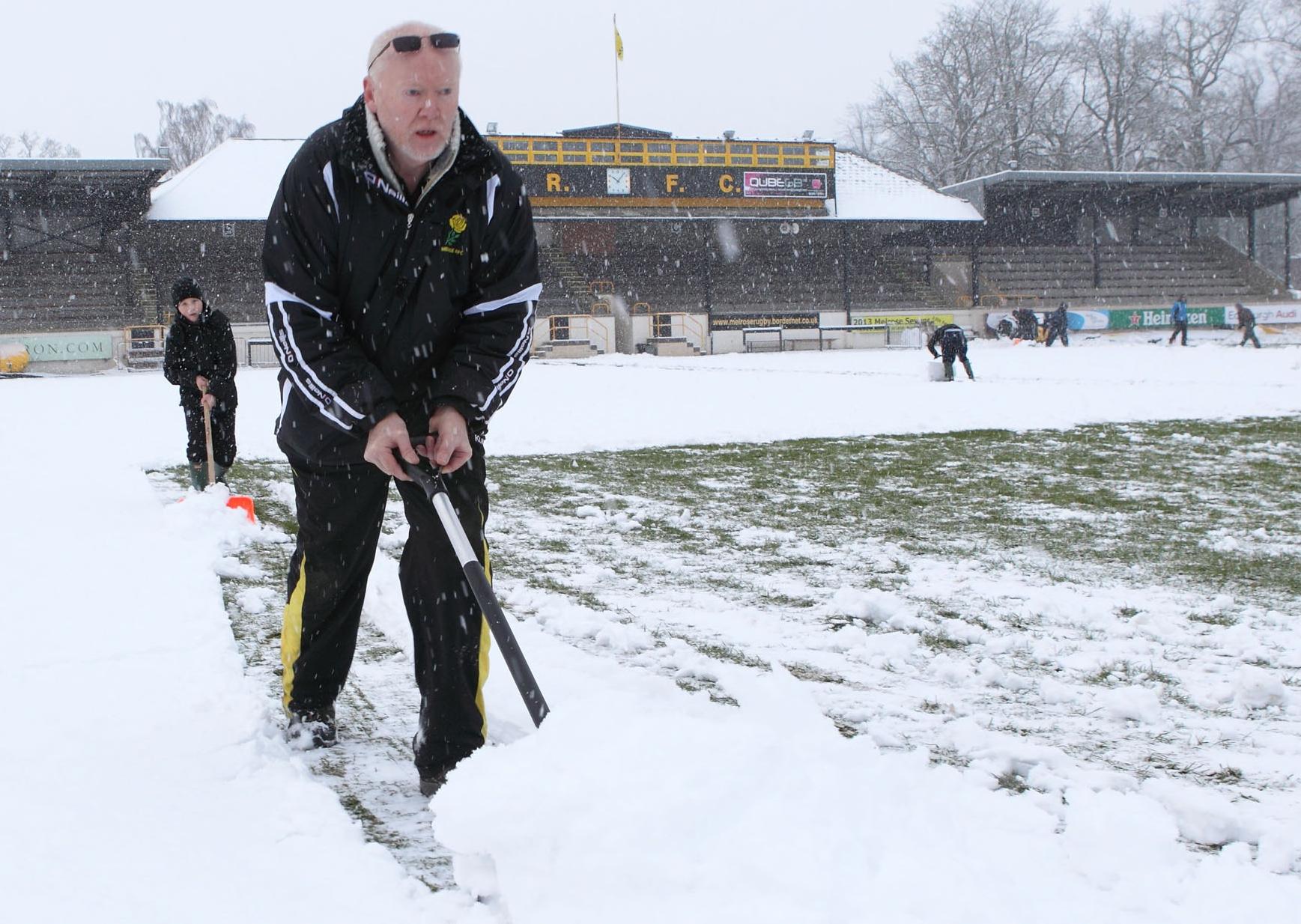 Clearing snow off the pitch at the Greenyards ahead of a game between Melrose and Doncaster.