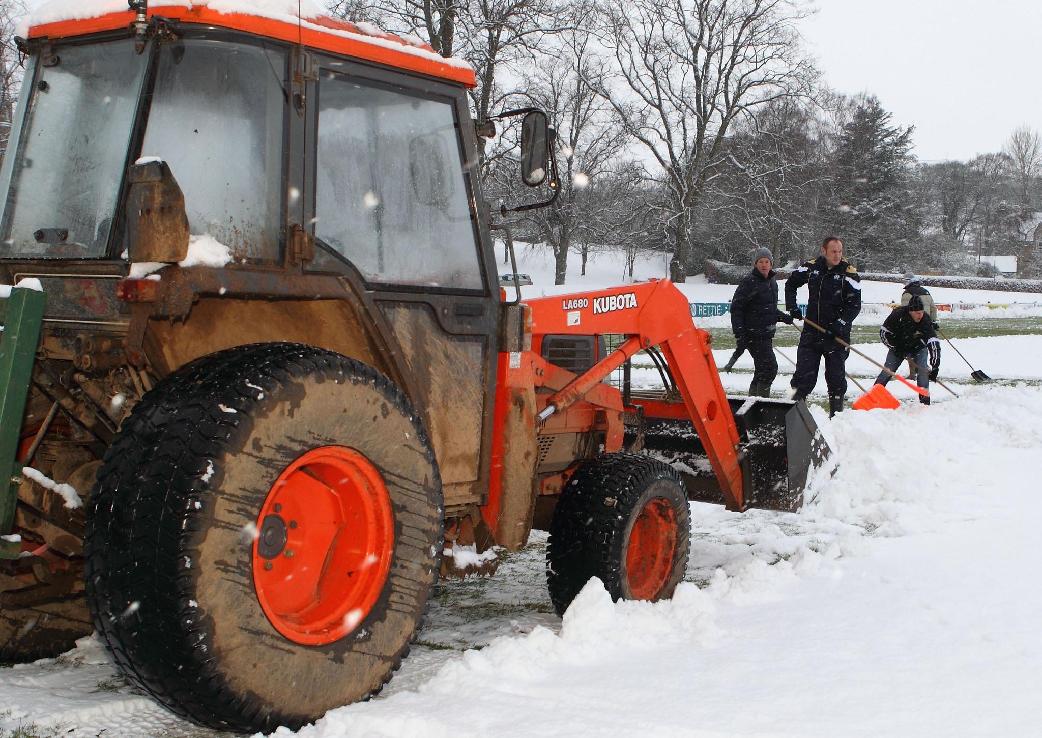 Clearing snow off the pitch at the Greenyards ahead of the game between Melrose and Doncaster.
