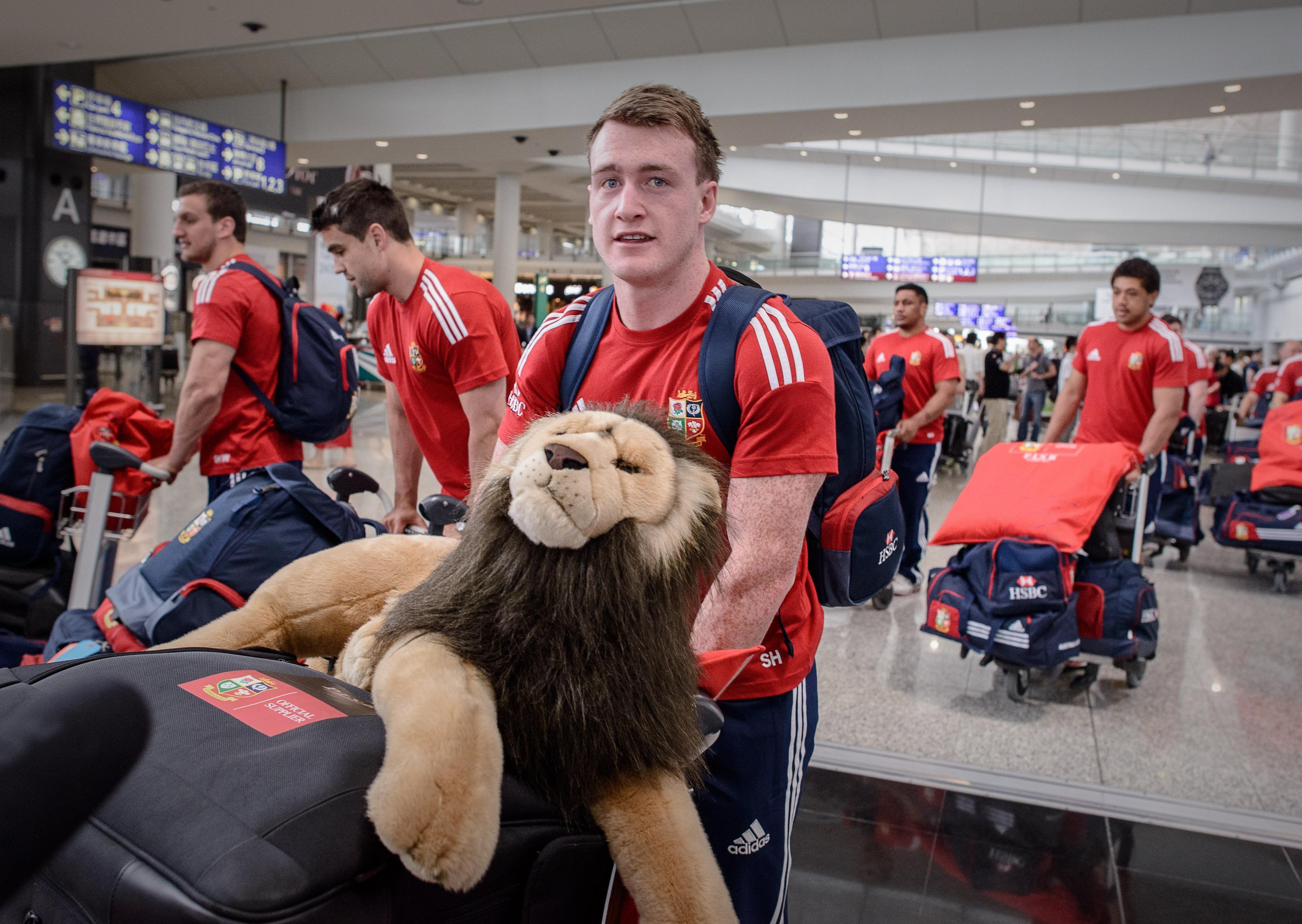 Scottish full-back Stuart Hogg carries the mascot of the British and Irish Lions as he and his teammates arrive in Hong Kong airport on May 28, 2013. The team arrived ahead of a month-long tour of Australia where they will seek their first Test series victory in 16 years. AFP PHOTO / Philippe Lopez        (Photo credit should read PHILIPPE LOPEZ/AFP via Getty Images)