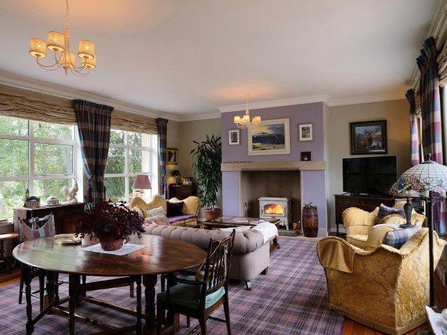 The drawing room has a wood burning stove and space for a dining area.
