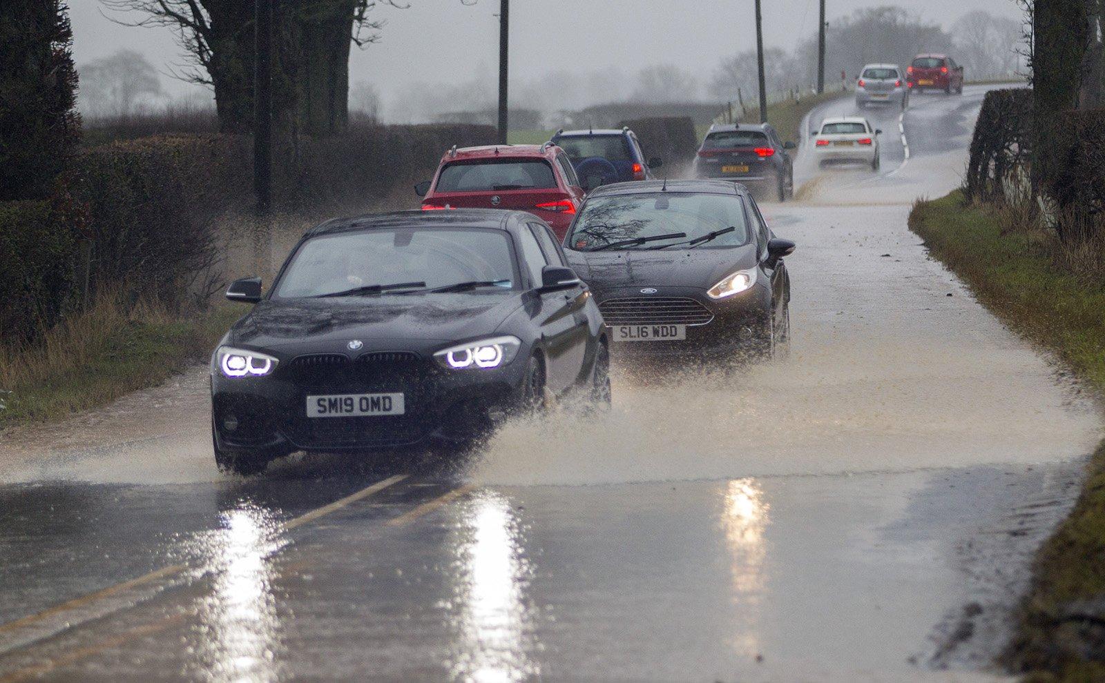 Cars going through standing water near Denholm on Saturday.