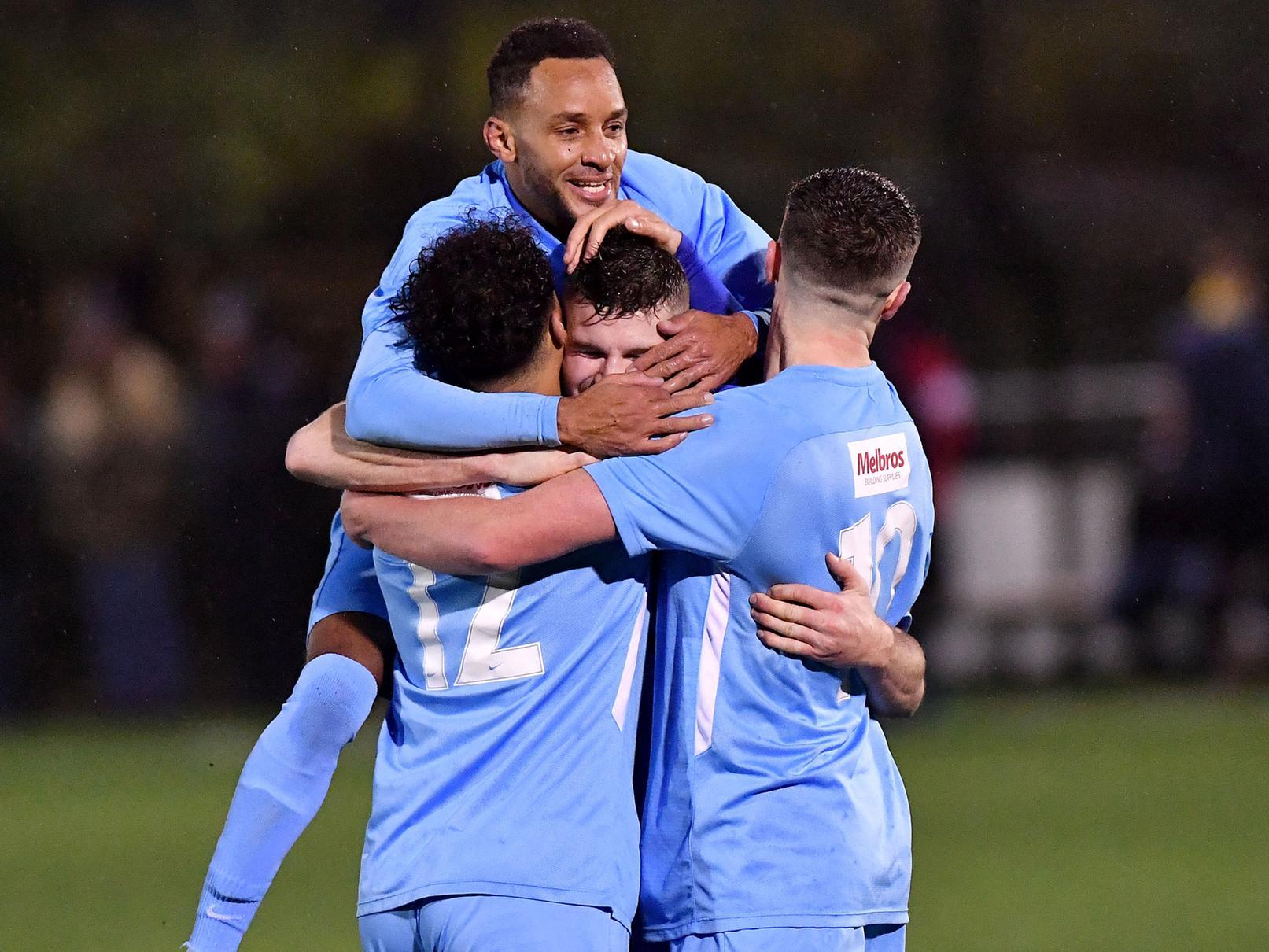 Charlie Evans is mobbed after scoring Rugby Town's second goal with six minutes to go   PICTURES BY MARTIN PULLEY