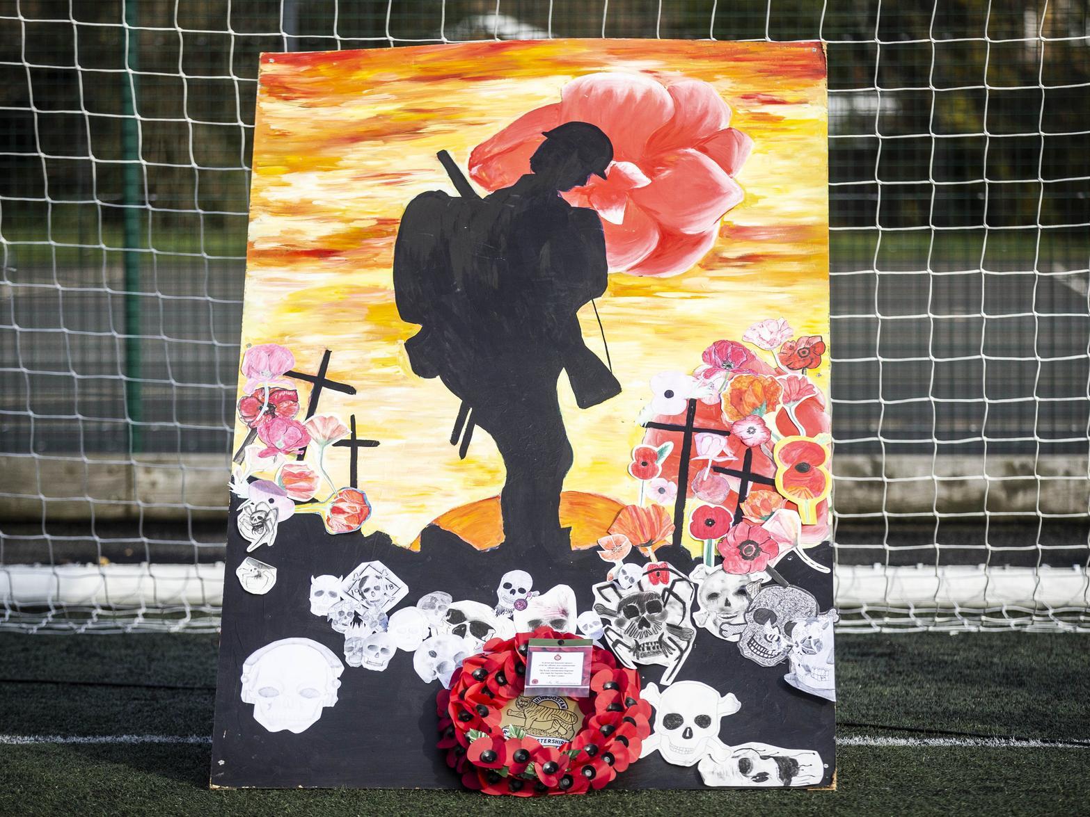 A wreath was laid by a mural produced by the art department.