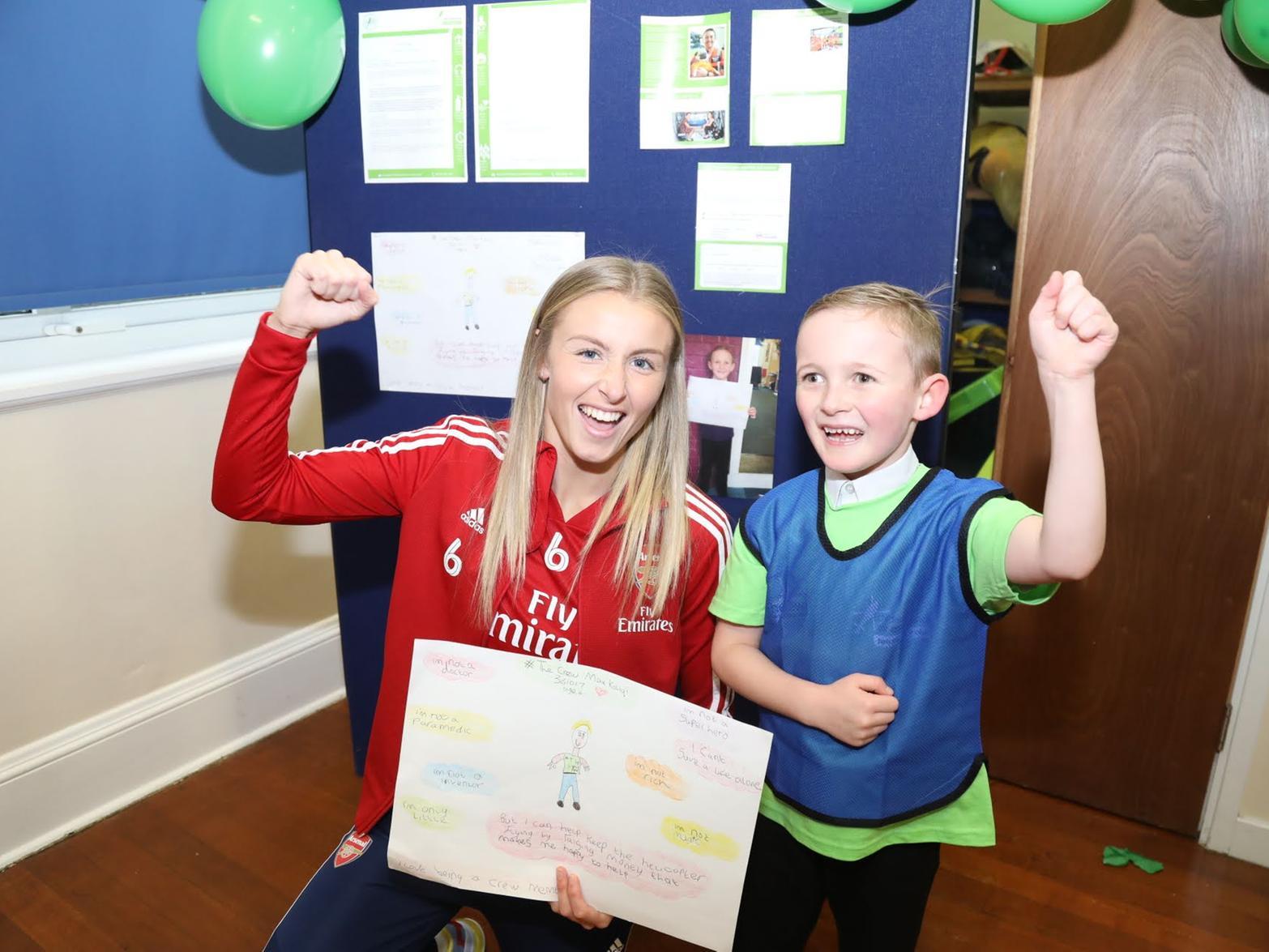 Max Koliqi, six, celebrates his winning poster with England and Arsenal football player, Leah Williamson.