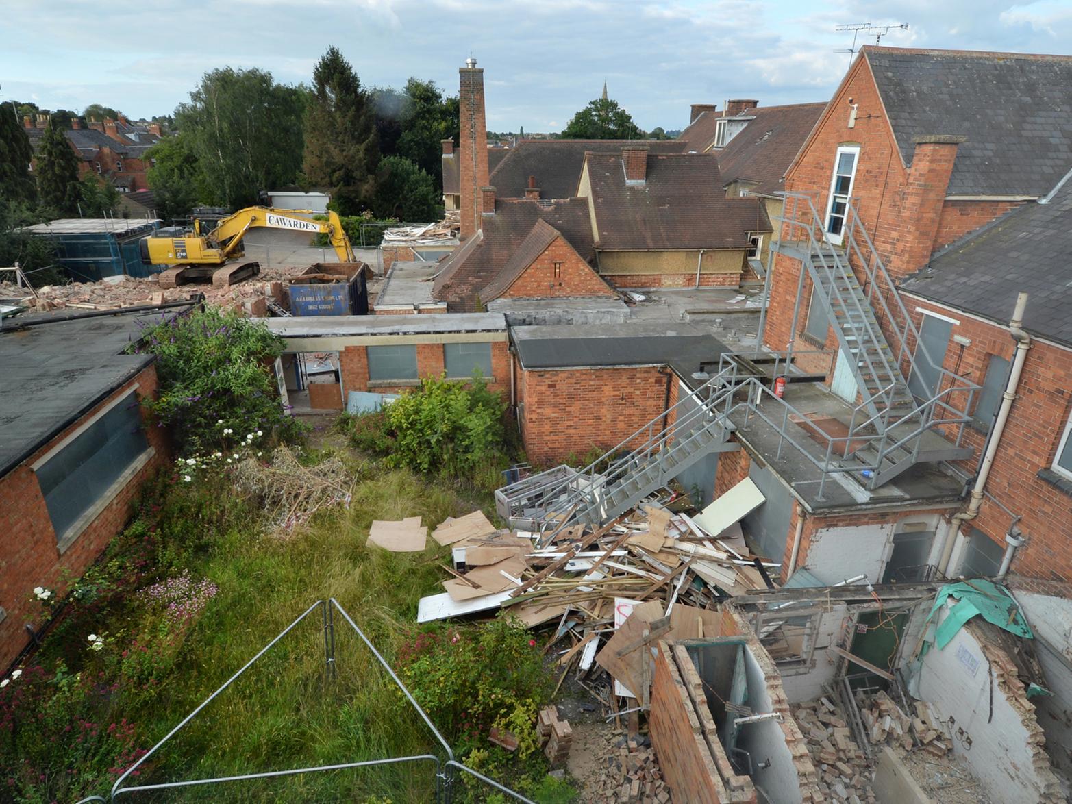 Work to demolish Market Harborough's old cottage hospital got underway in July.
Crews moved in to demolish the former cottage hospital off Coventry Road in Market Harborough.
The work will clear most of the site in preparation for a luxury new 70-bed care home. The Grade II listed war memorial portico will be carefully retained and incorporated into the new building.
The red brick-built care home will occupy much the same footprint as the redundant hospital, developers say.