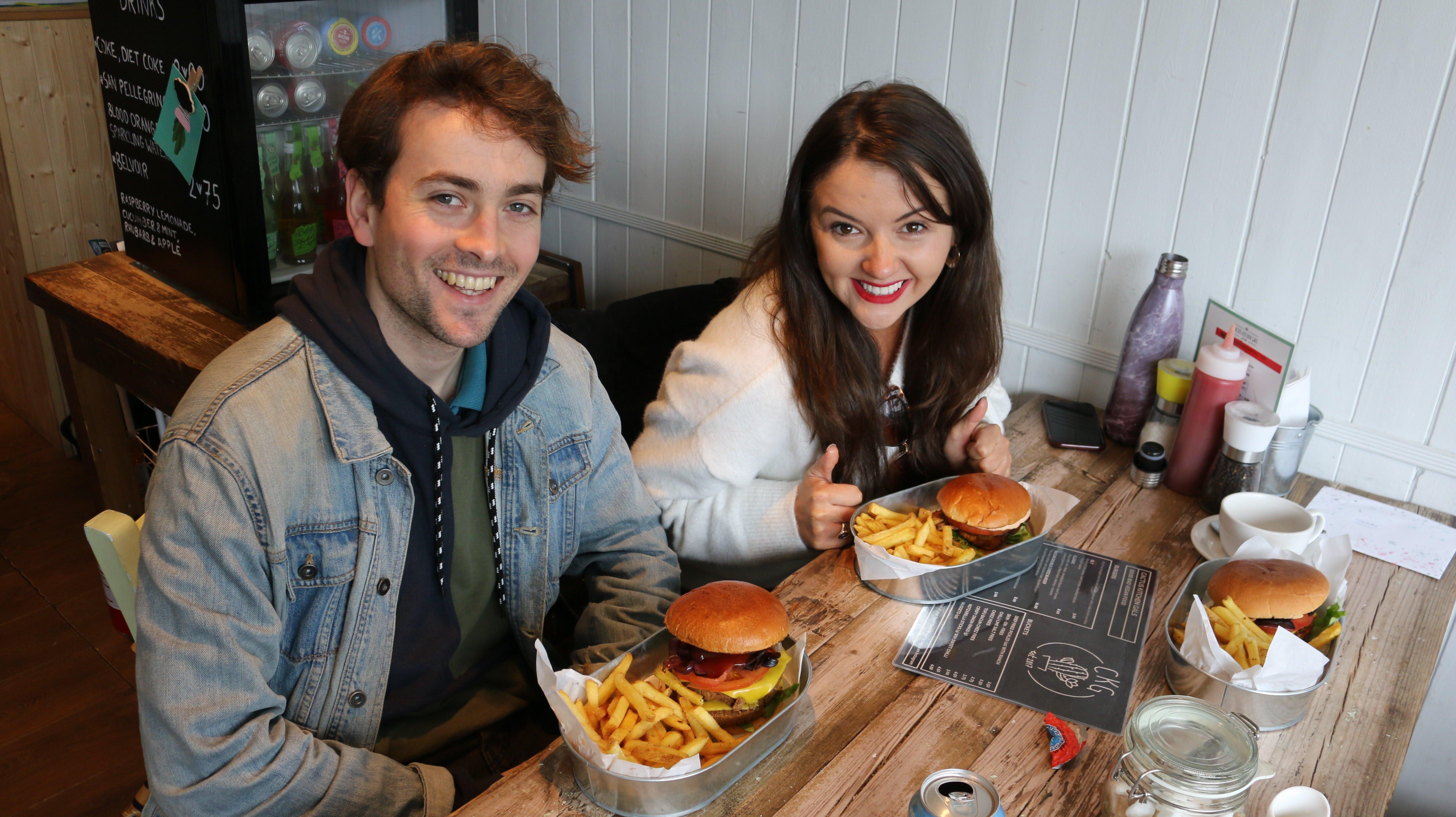 Tom England and Jasmyn Banks tucking into burger and chips SUS-190404-104602003