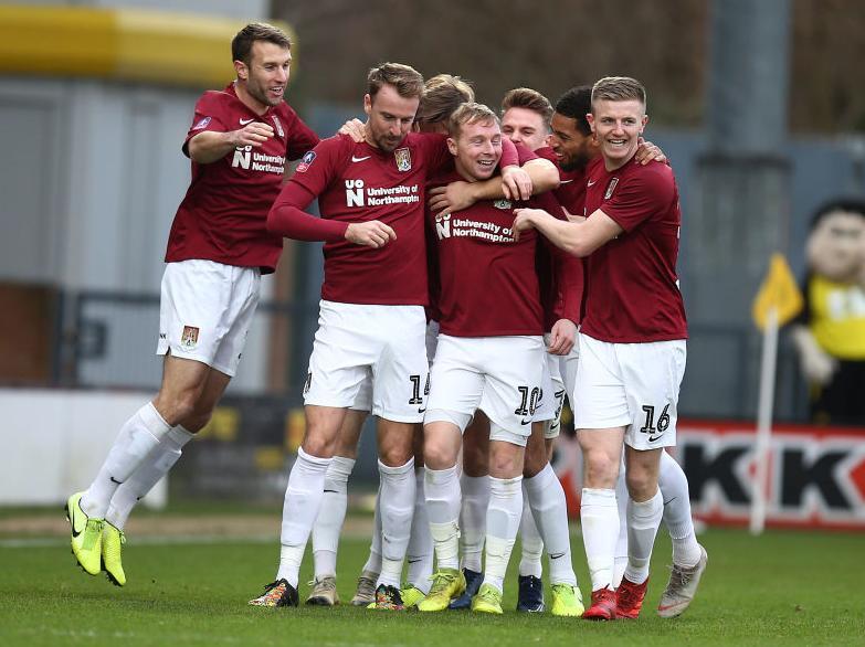 The Cobblers players celebrate Nicky Adams' opening goal
