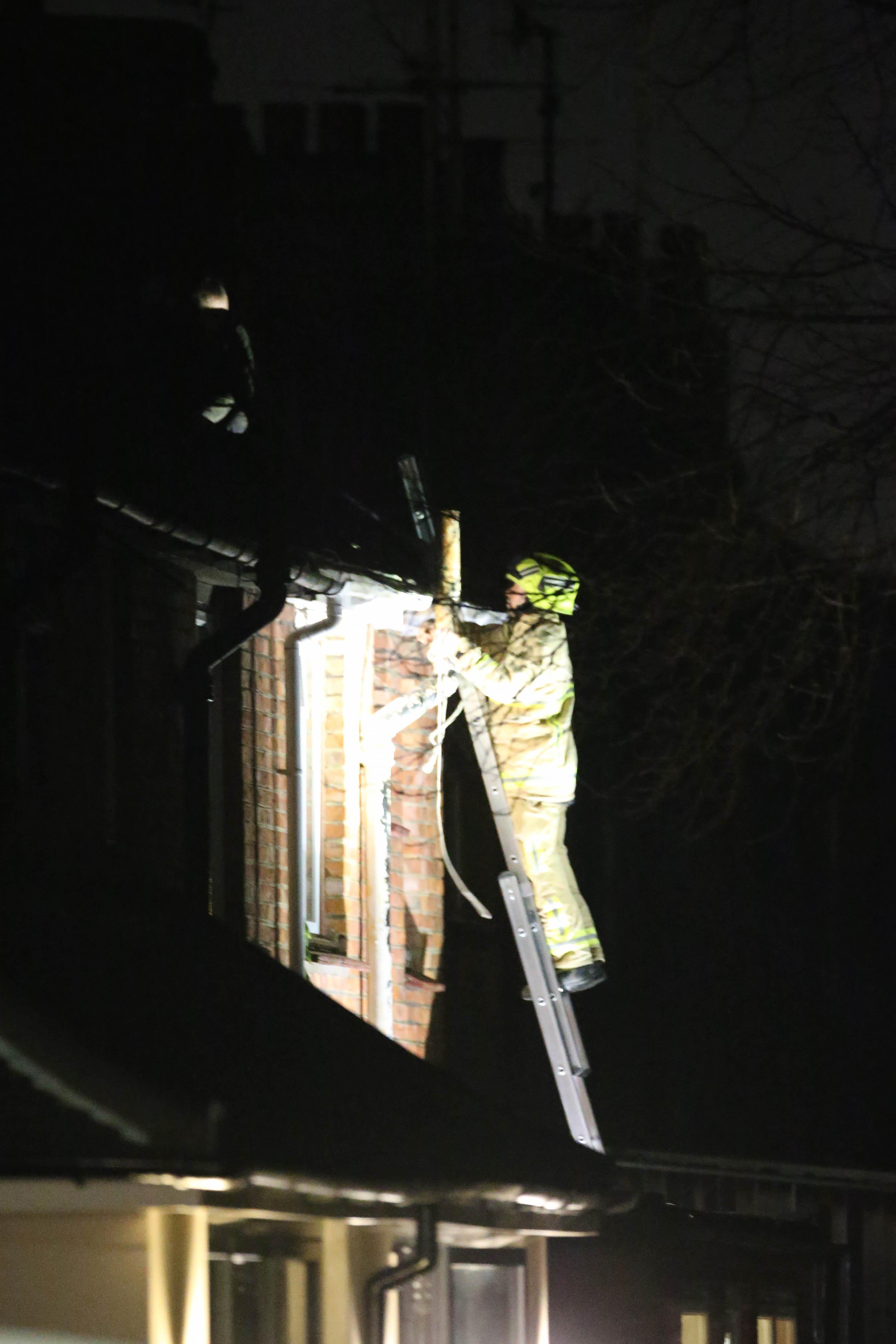 A firefighter bravely confronted the man after reaching the roof of the house.