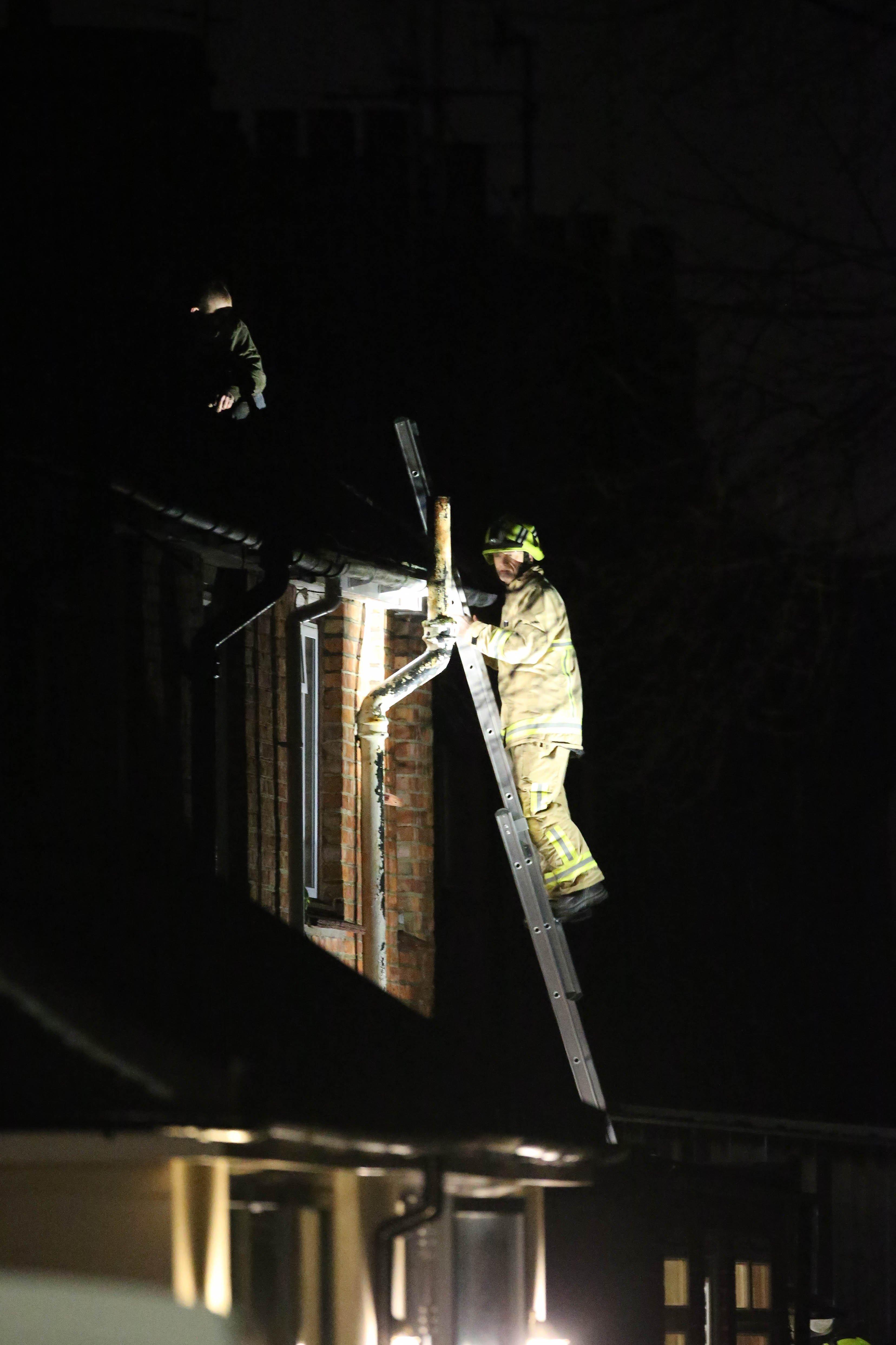 A firefighter scales the building
