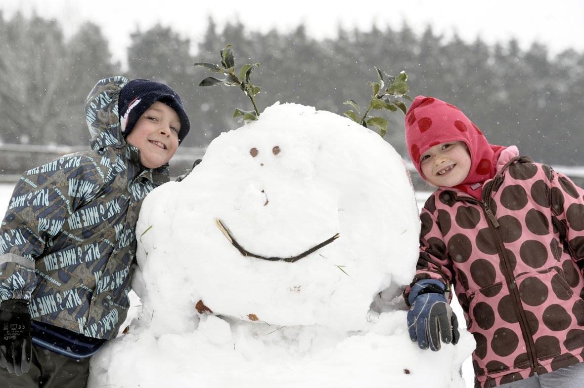 Children build a giant snowman in the absence of school