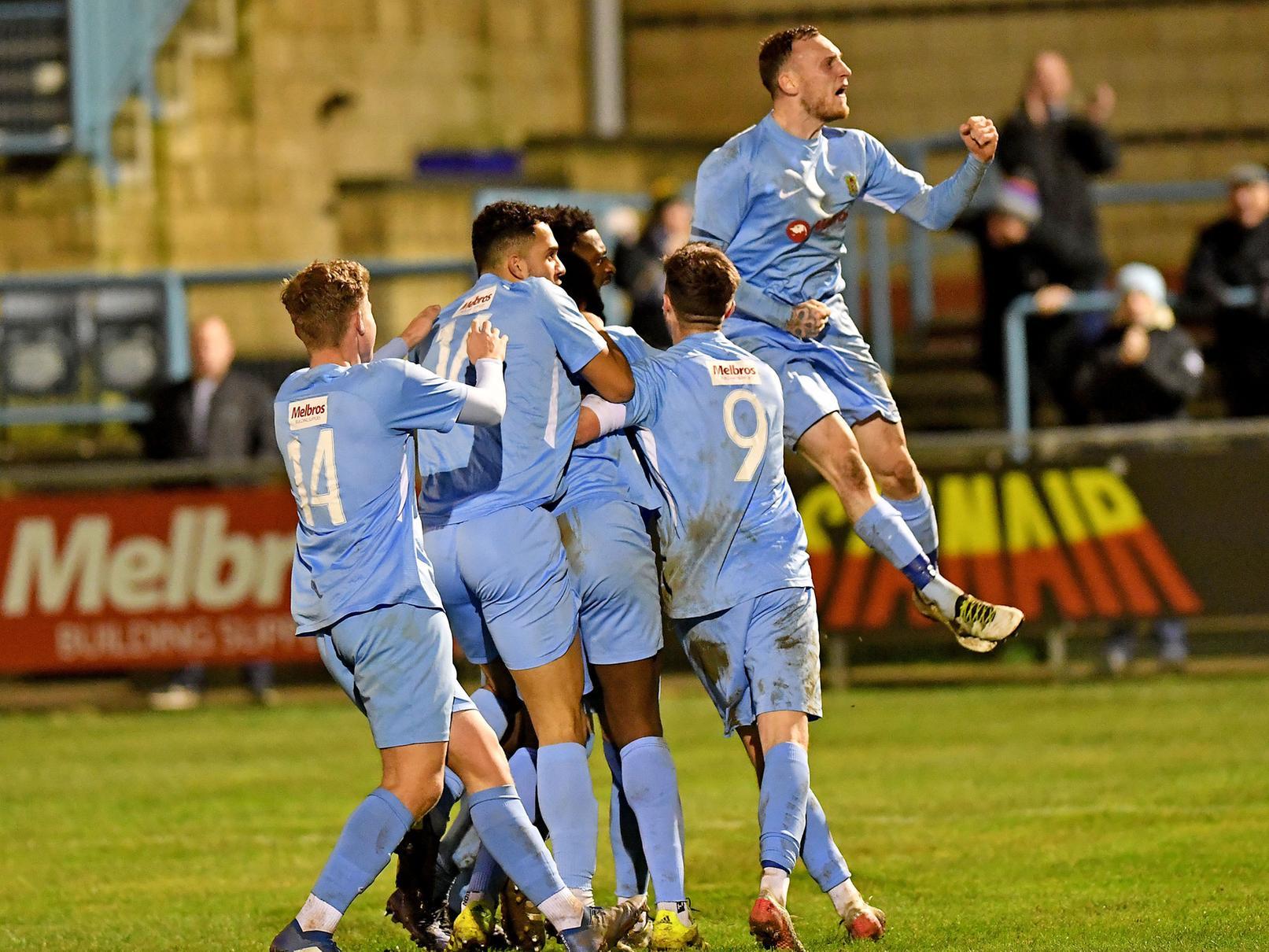 Ecstatic Rugby Town celebrate their 95th-minute winner against Deeping Rangers