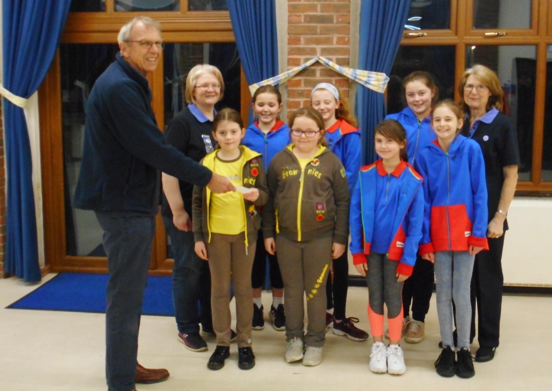 1st Sullington Brownies receiving a cheque for £500 from Rotarian Tony Vaughan SUS-201202-114728001