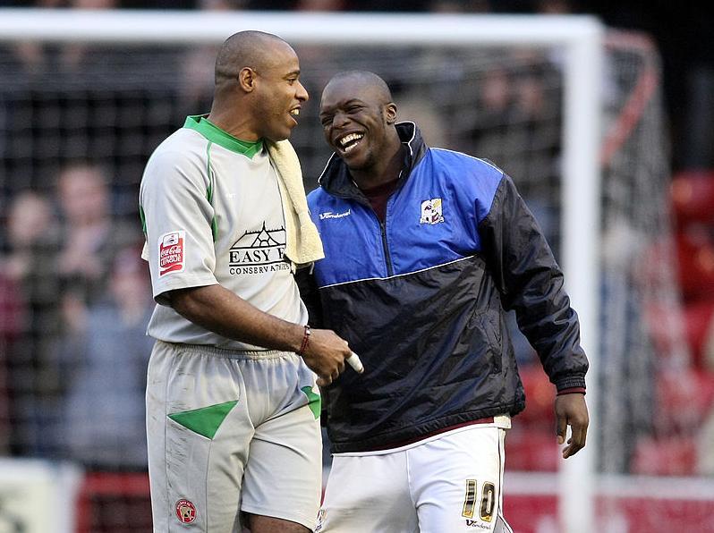 Adebayo Akinfenwa shares a joke with Walsall goalkeeper Clayton Ince after the match