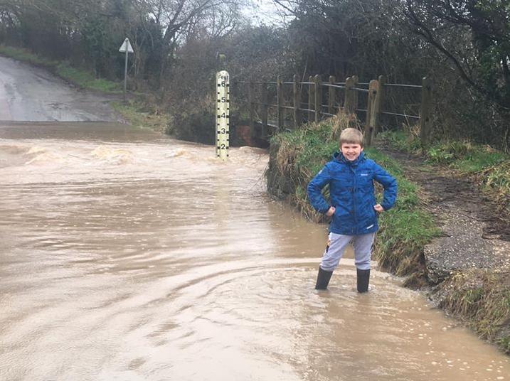 Oliver Morris stands in the flooded roadway at the ford crossing in Rouncil Lane near the village of Beausale (photo by Simon Morris)