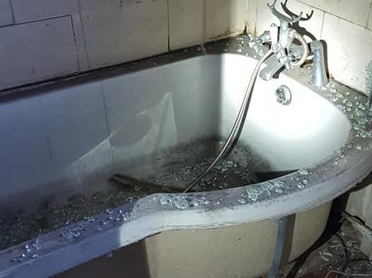 A bath surrounded by broken glass
Photo by Annie Skelton