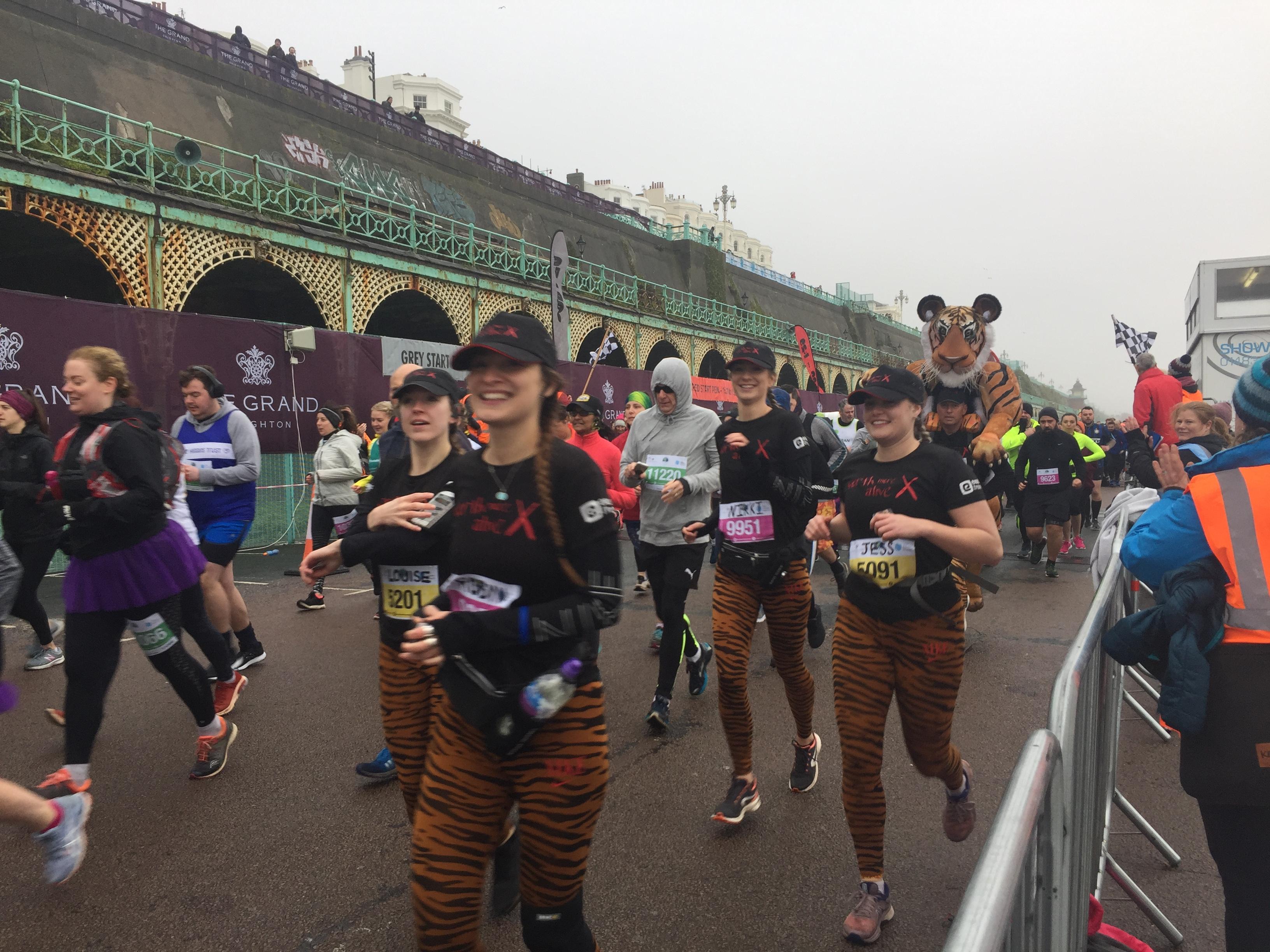 A marathon runner with a giant tiger and his entourage