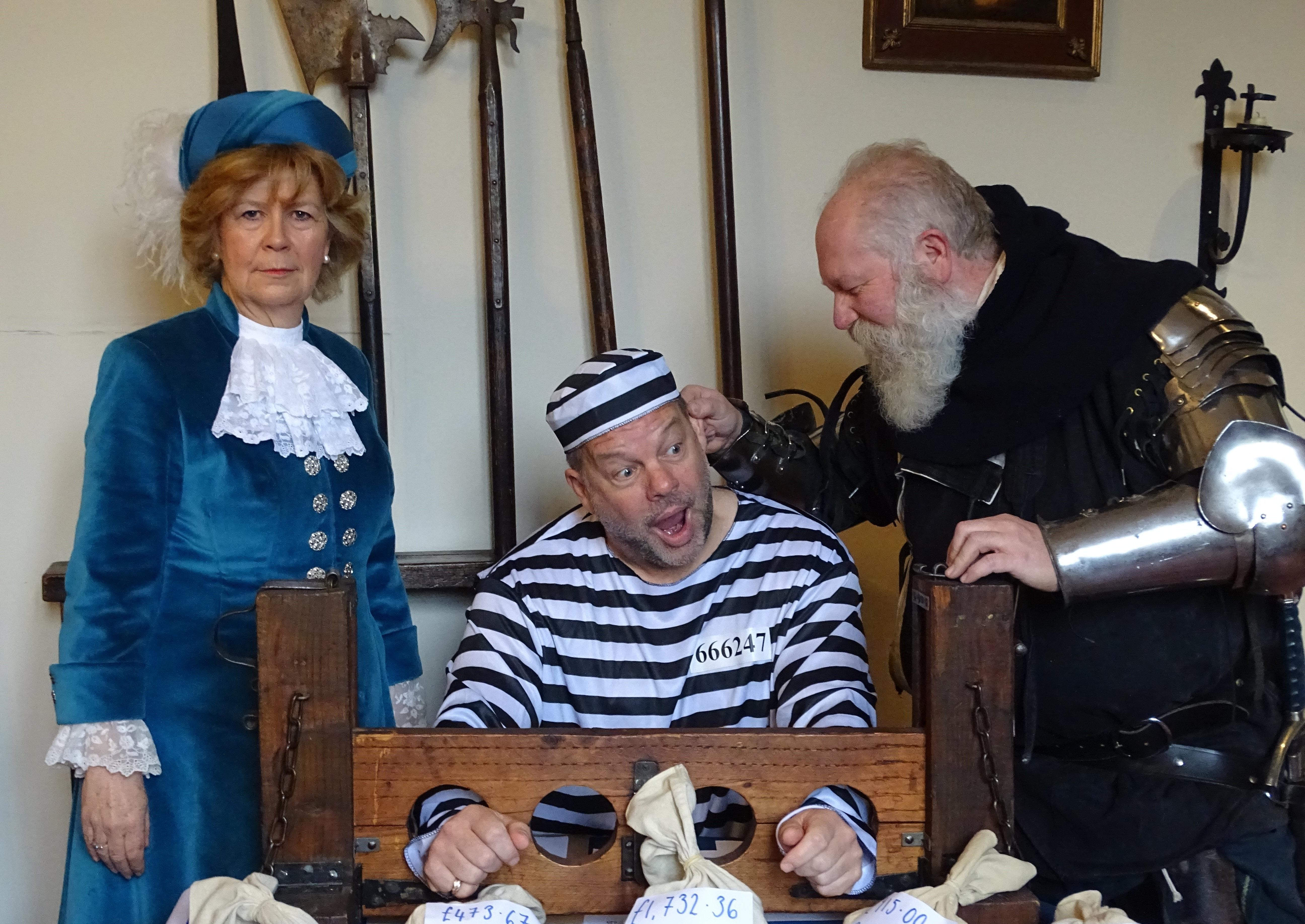 Alan Easter in the stocks, with High Sheriff of West Sussex Davina Irwin-Clark and jailer Chris Blatch-Gainey