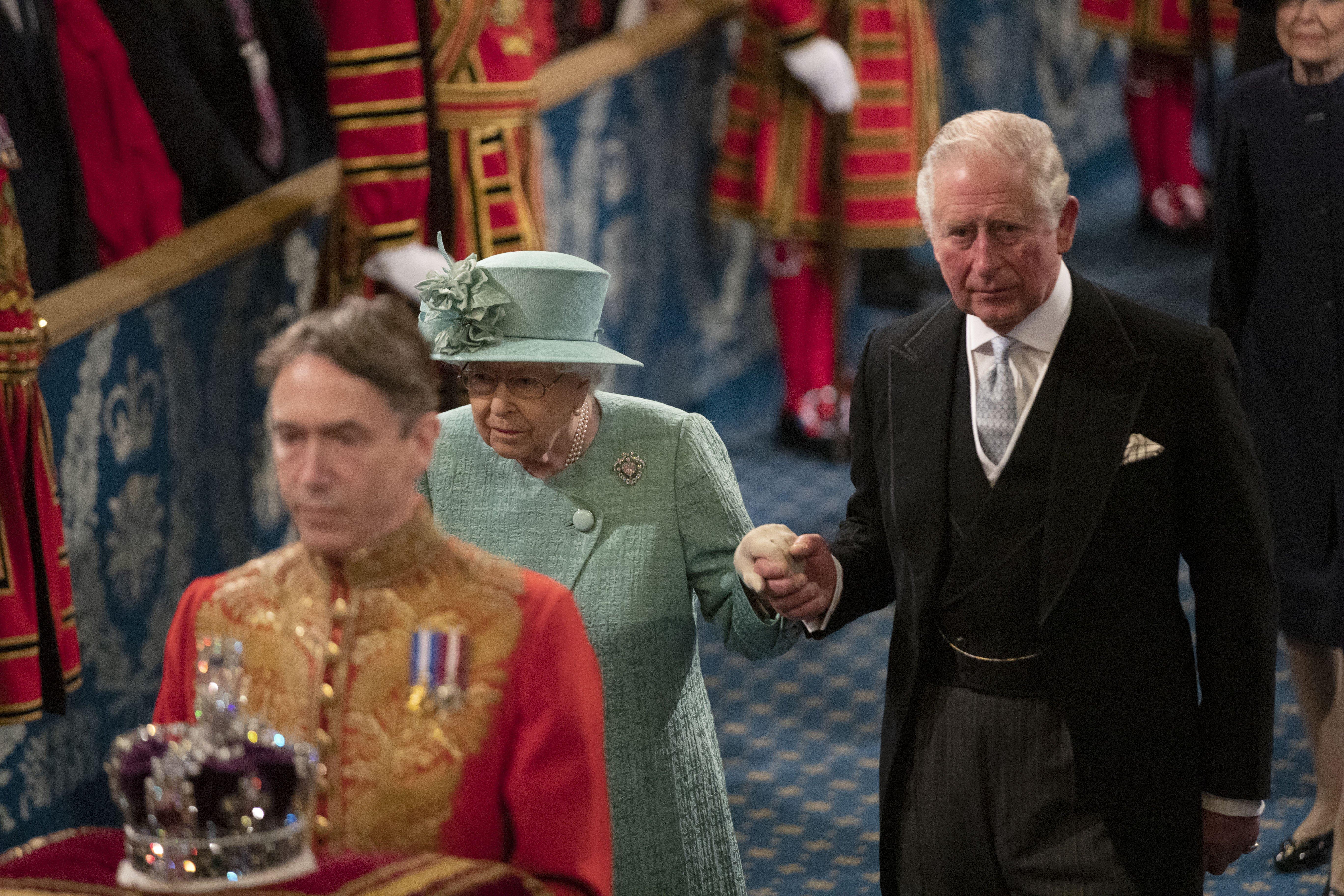 Queen Elizabeth II, accompanied by the Prince of Wales, proceed through the Royal Gallery before delivering the Queen's Speech during the State Opening of Parliament in the House of Lords at the Palace of Westminster in London