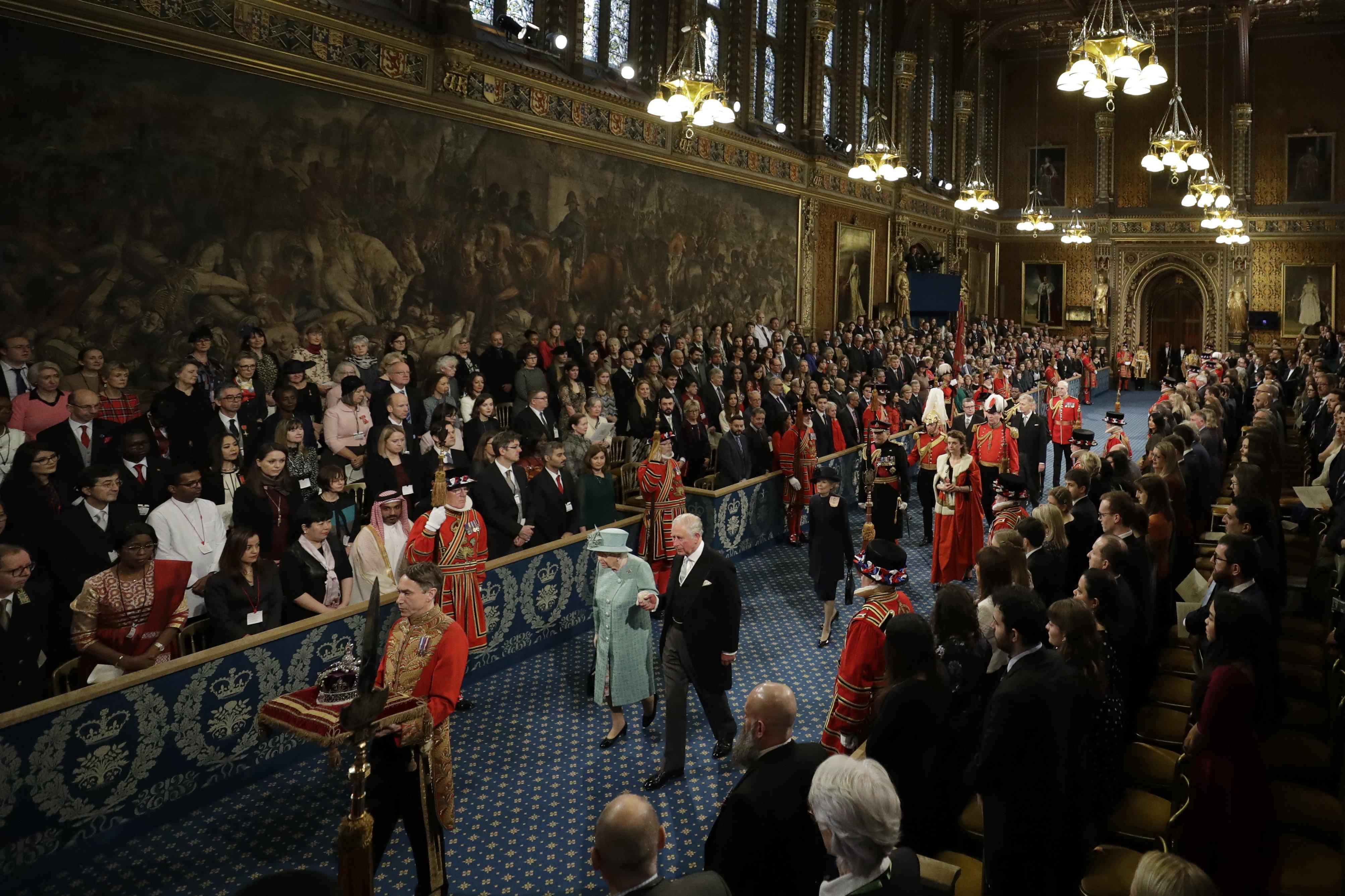 Queen Elizabeth II, accompanied by the Prince of Wales, proceed through the Royal Gallery before delivering the Queen's Speech during the State Opening of Parliament in the House of Lords at the Palace of Westminster in London.