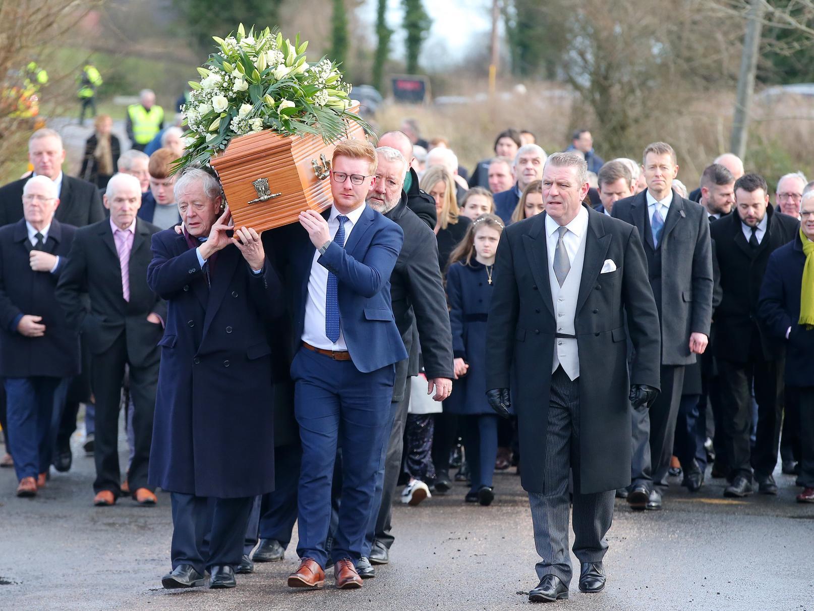 Mourners walk the final few steps carrying the coffin of Seamus Mallon into St James of Jerusalem Church in Mullaghbrack, Co. Armagh.