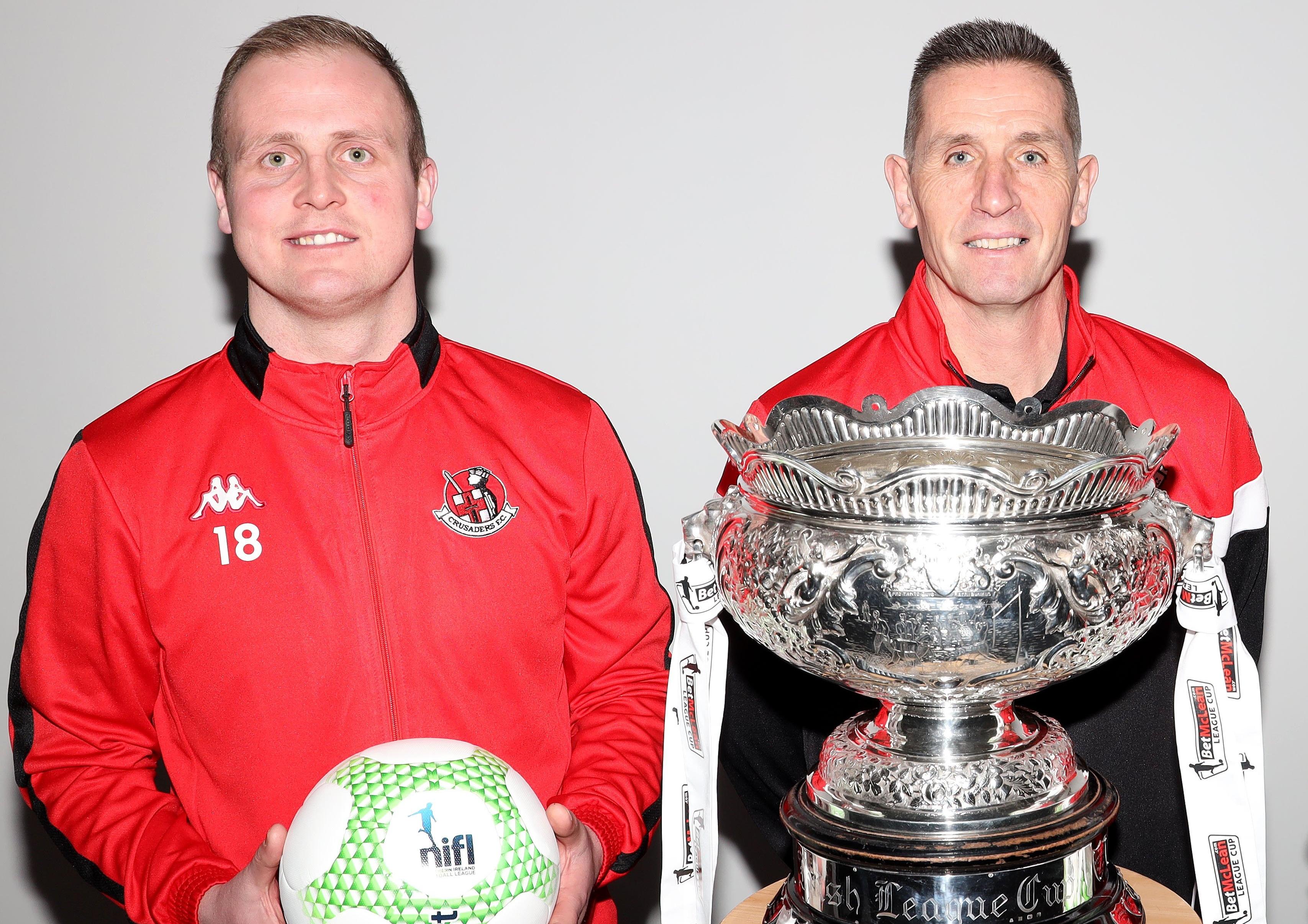 Crusaders striker Jordan Owens (left) and manager Stephen Baxter in front of the League Cup trophy. Pic by Pacemaker.